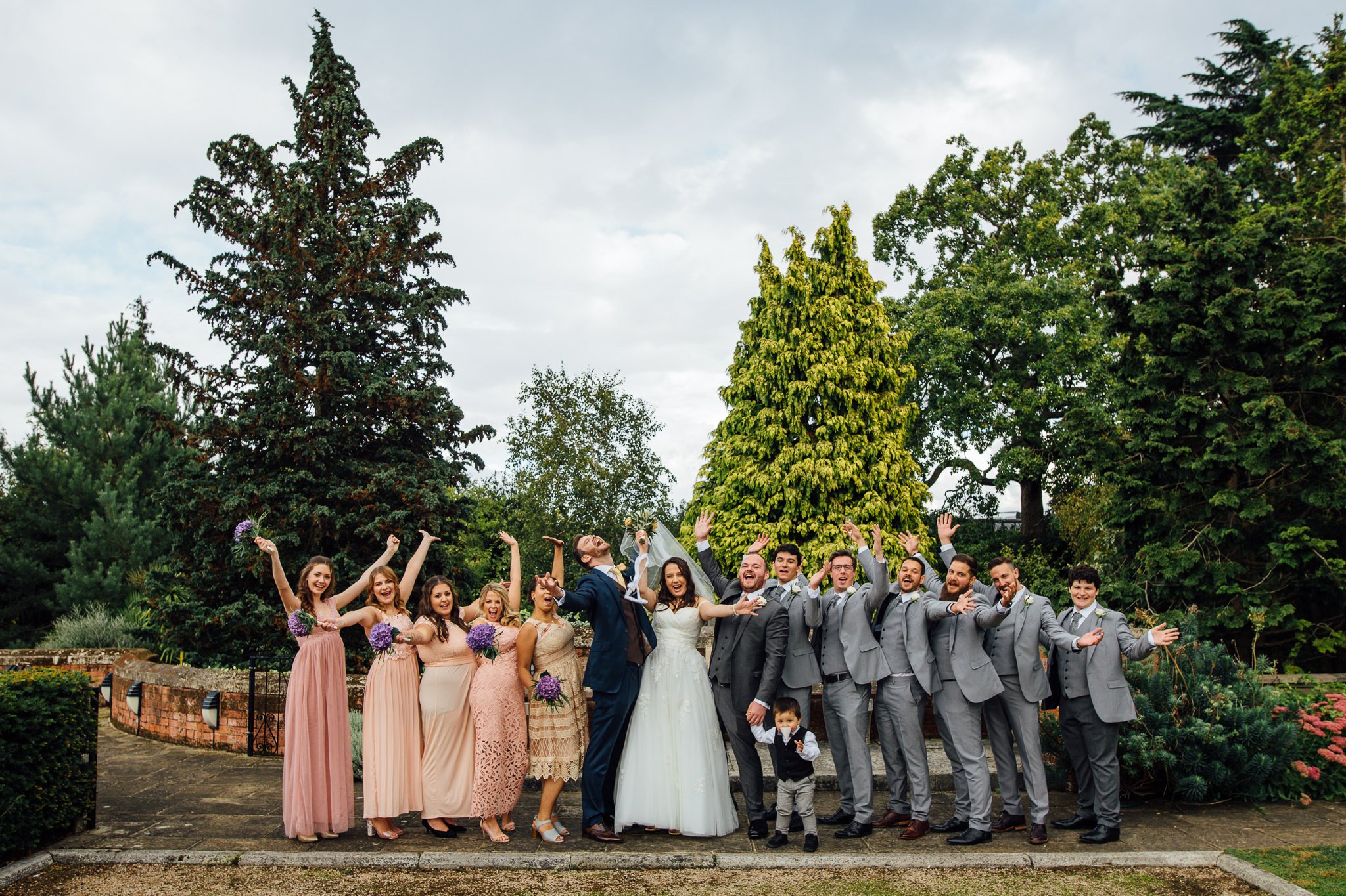  Bridal party and Groomsmen throw their arms in the air at Warren House Hotel Kingston upon Thames 