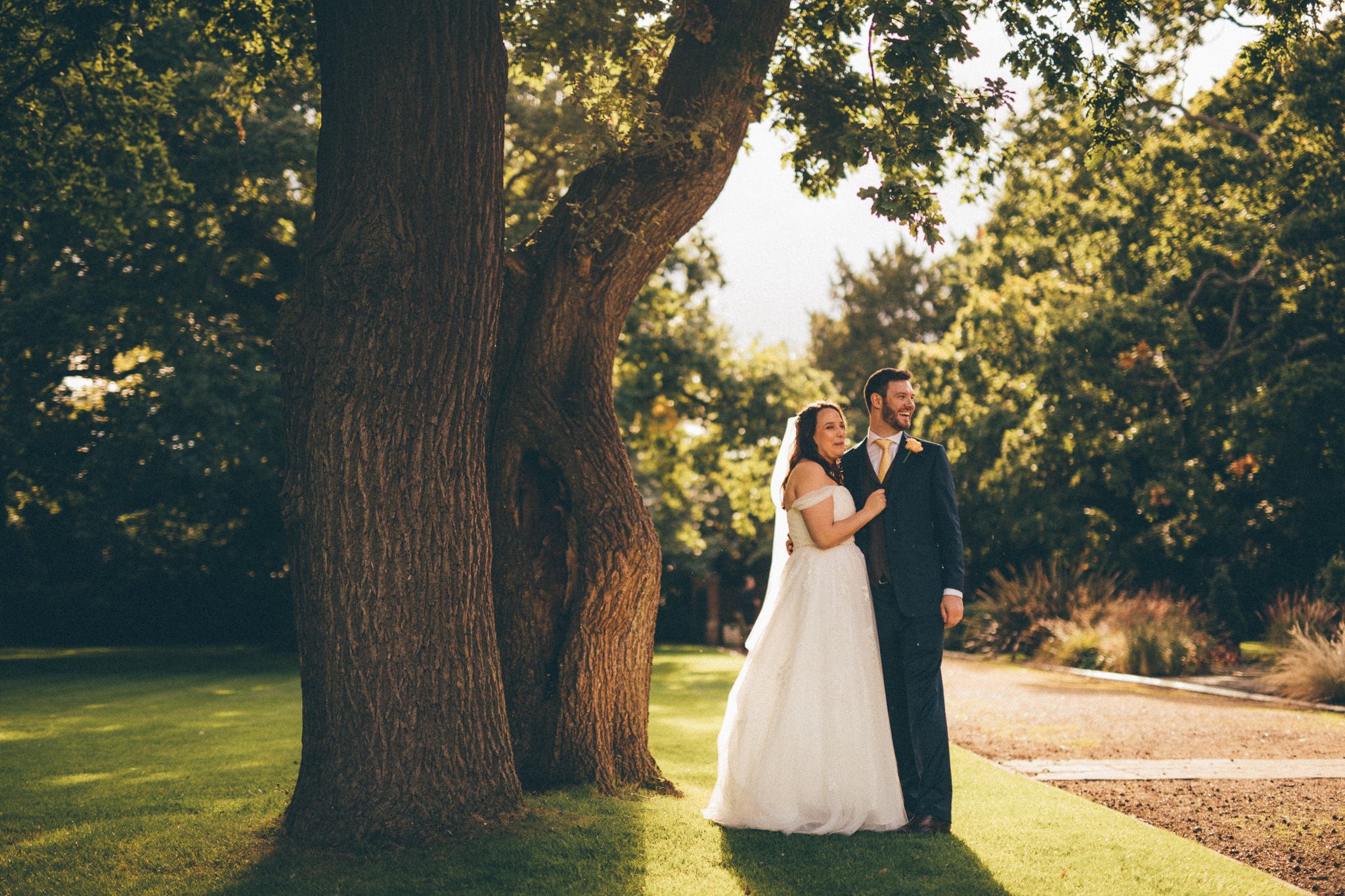  Bride and Groom stand next to a tree at Warren House Hotel Kingston upon Thames 