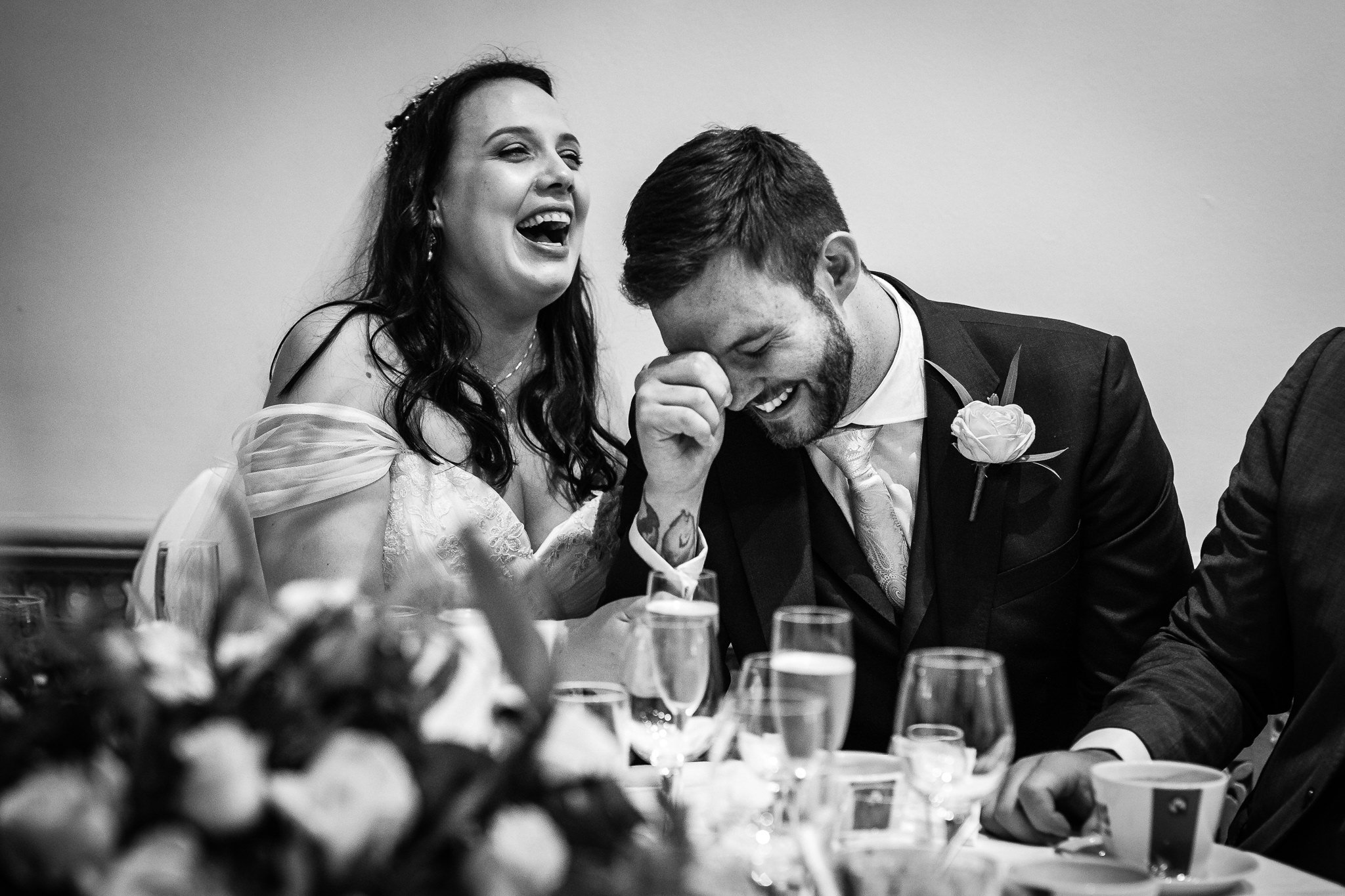  Bride and Groom laughing at a speech at Warren House Hotel Kingston upon Thames 