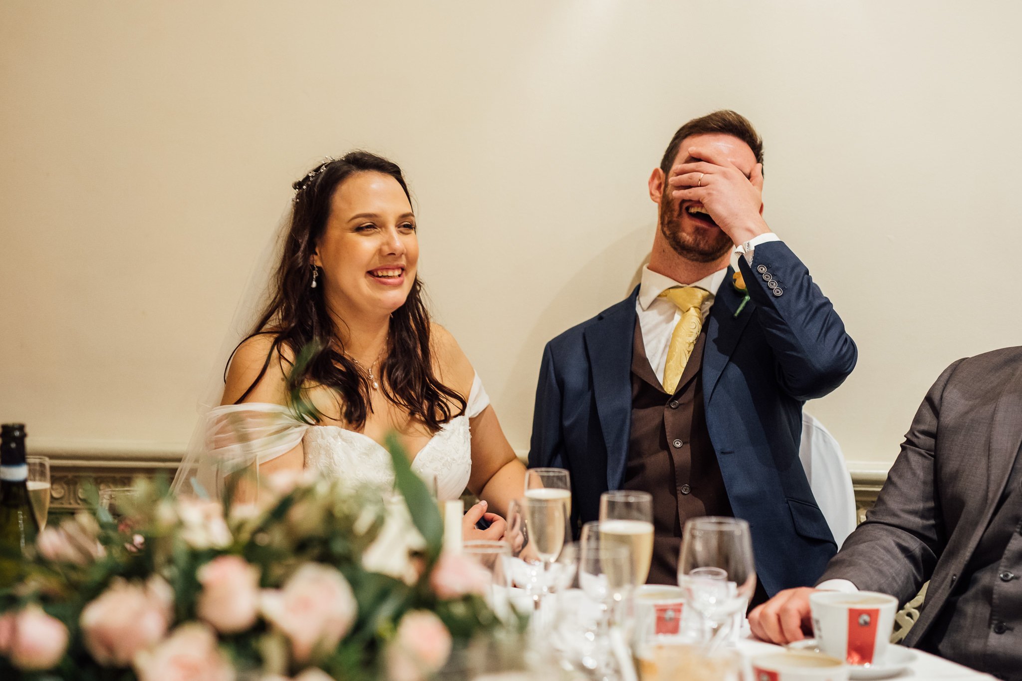  Groom covers his face with laughter at Warren House Hotel Kingston upon Thames 