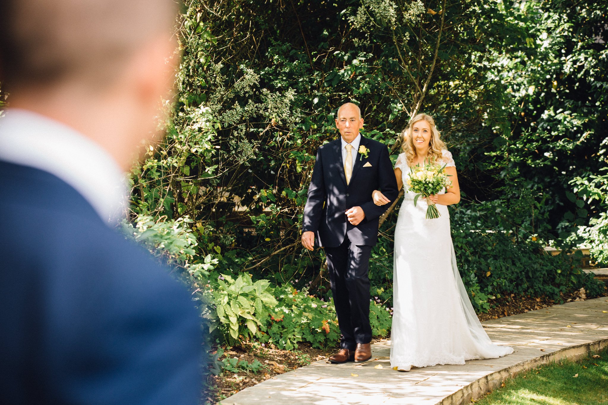  Bride and her father walking around the edge of the temple area at Micklefield Hall 