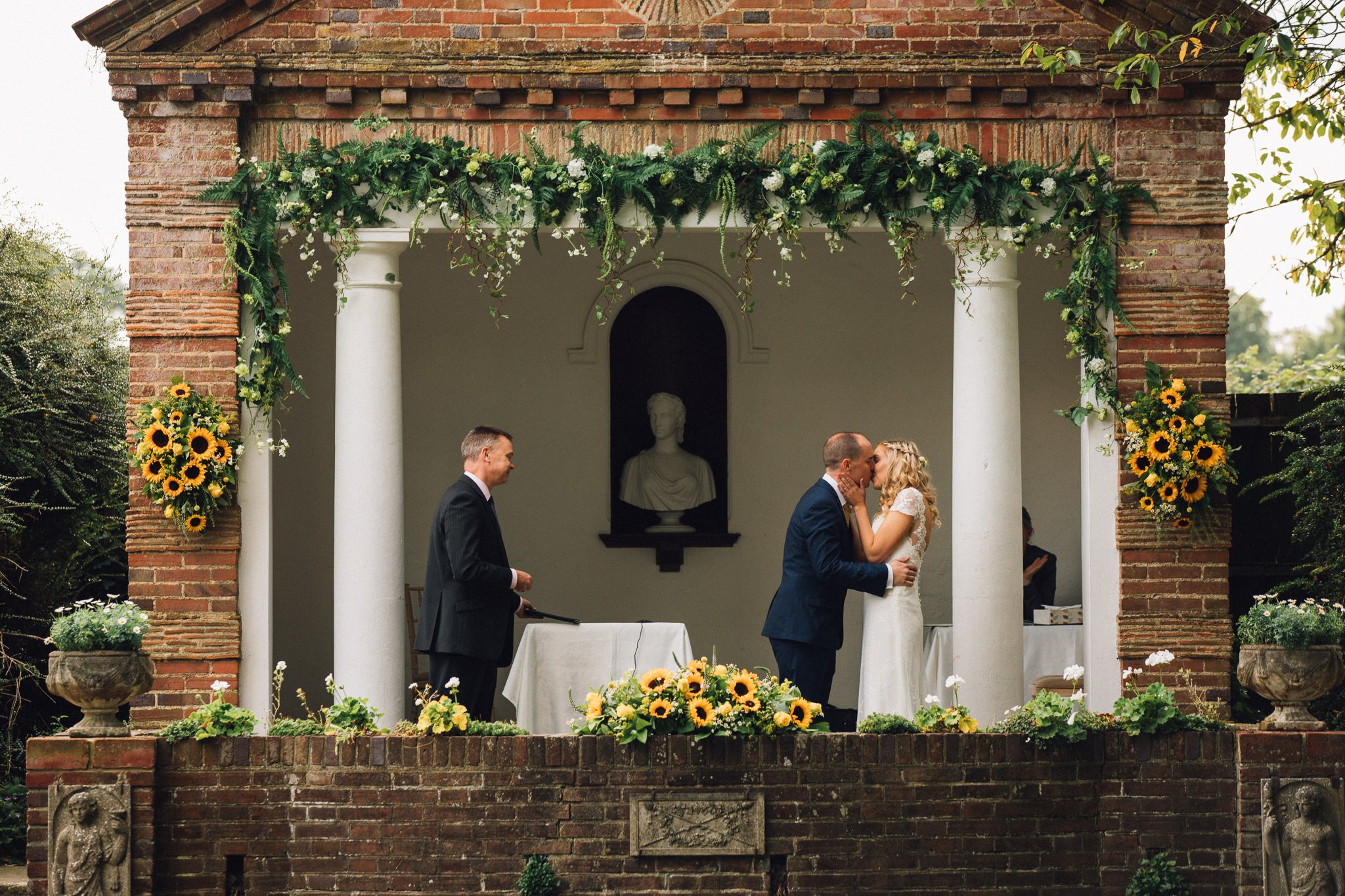  Bride and Groom kiss in front of the Temple at Micklefield Hall 