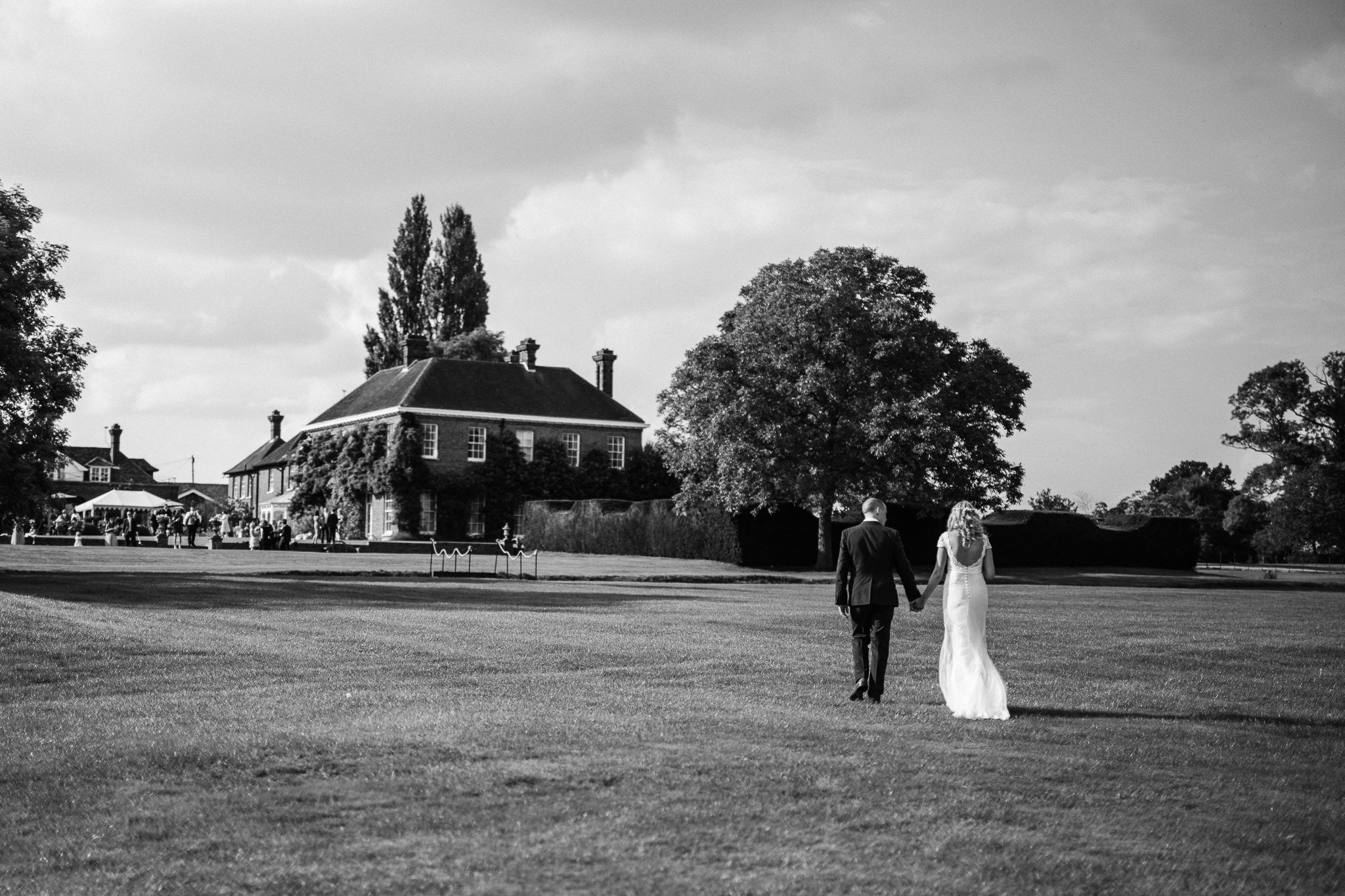  Bride and Groom walk hand in hand up towards Micklefield Hall 