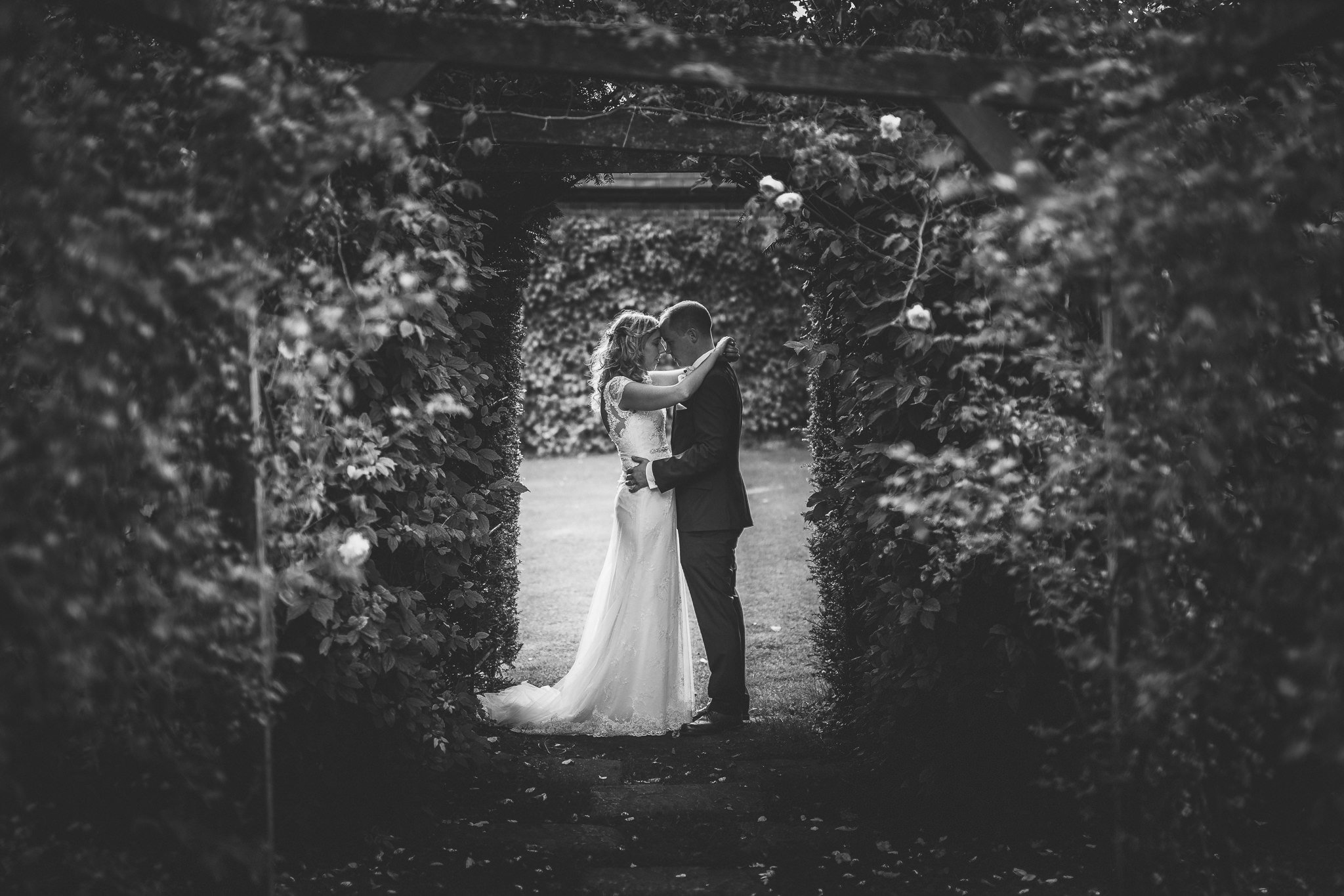  Bride and Groom touching foreheads in a wooded area at Micklefield Hall 