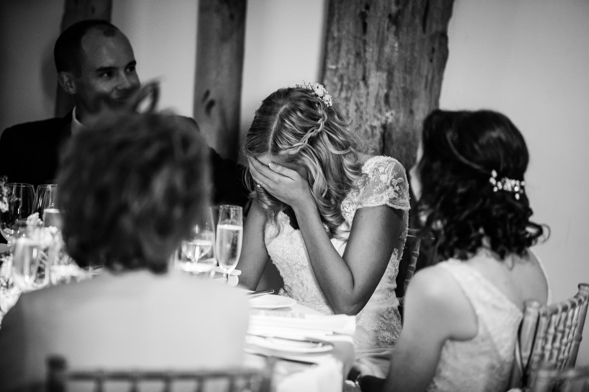  Bride covers her face in embarrassment during the wedding speeches 
