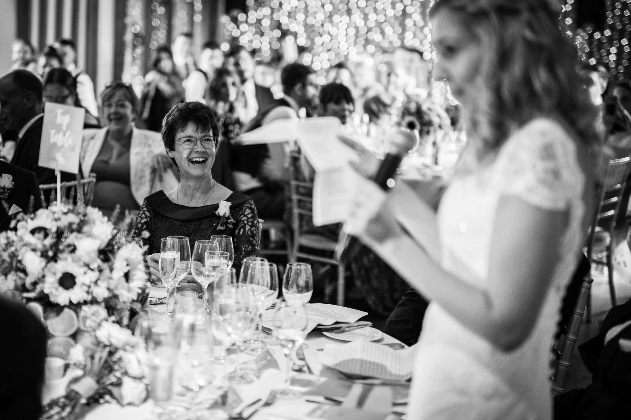  Mother of the Groom laughs during the speeches 