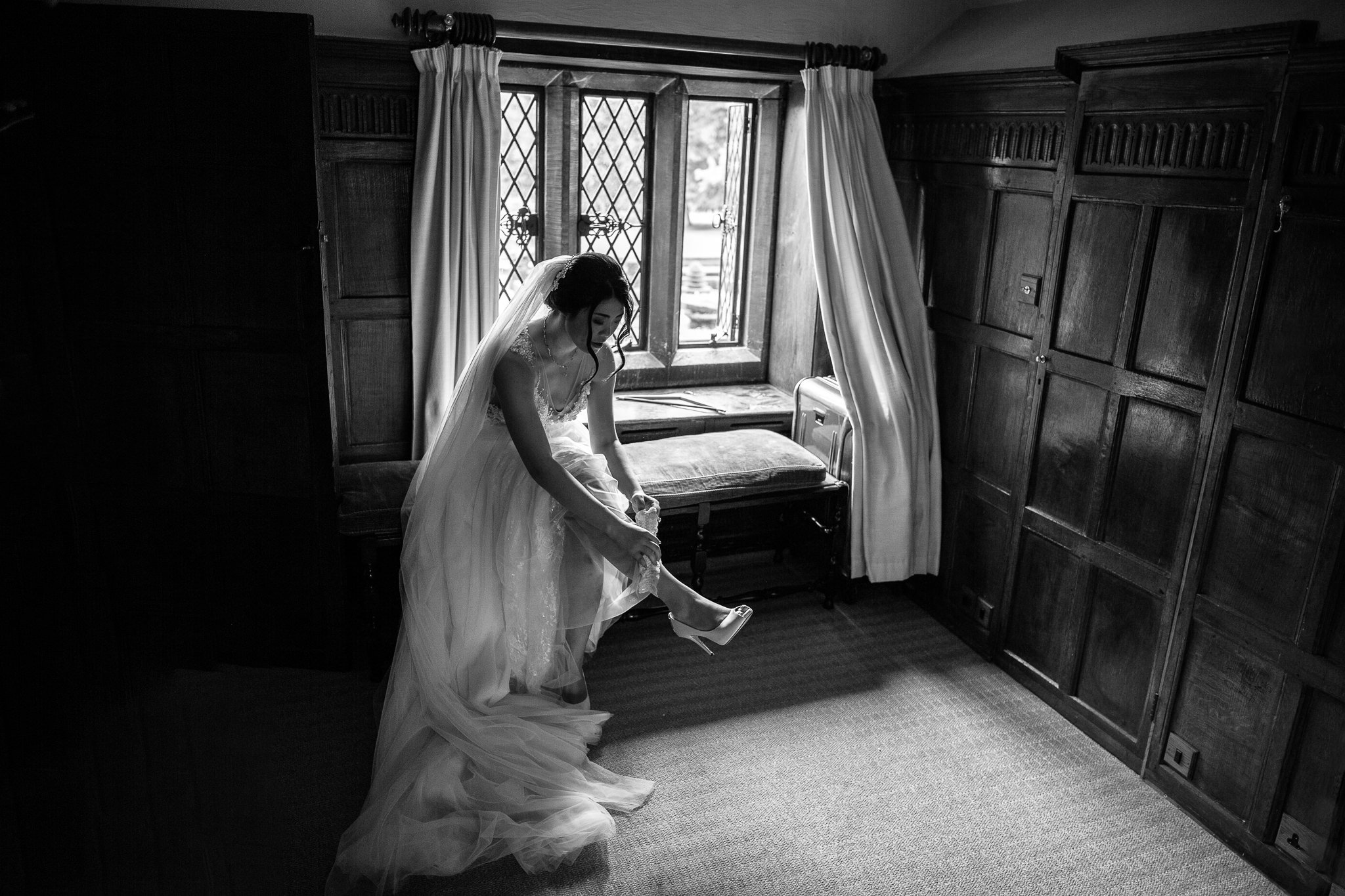  Bride puts on her garter at Great Fosters Egham 