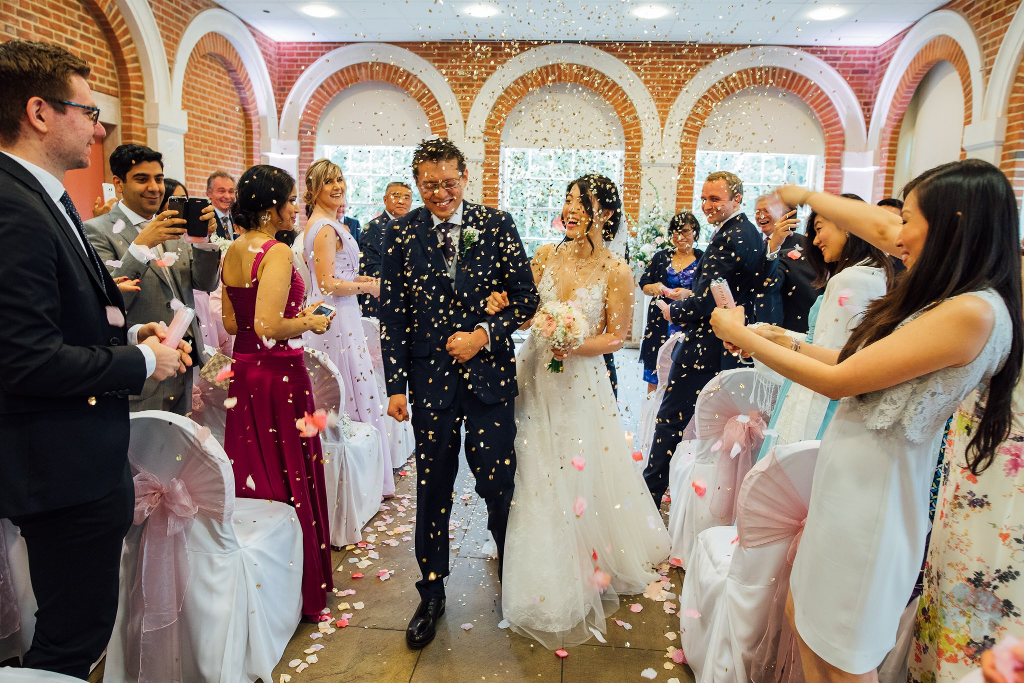  Bride and Groom walk down the aisle at Great Fosters Egham and have confetti thrown at them 
