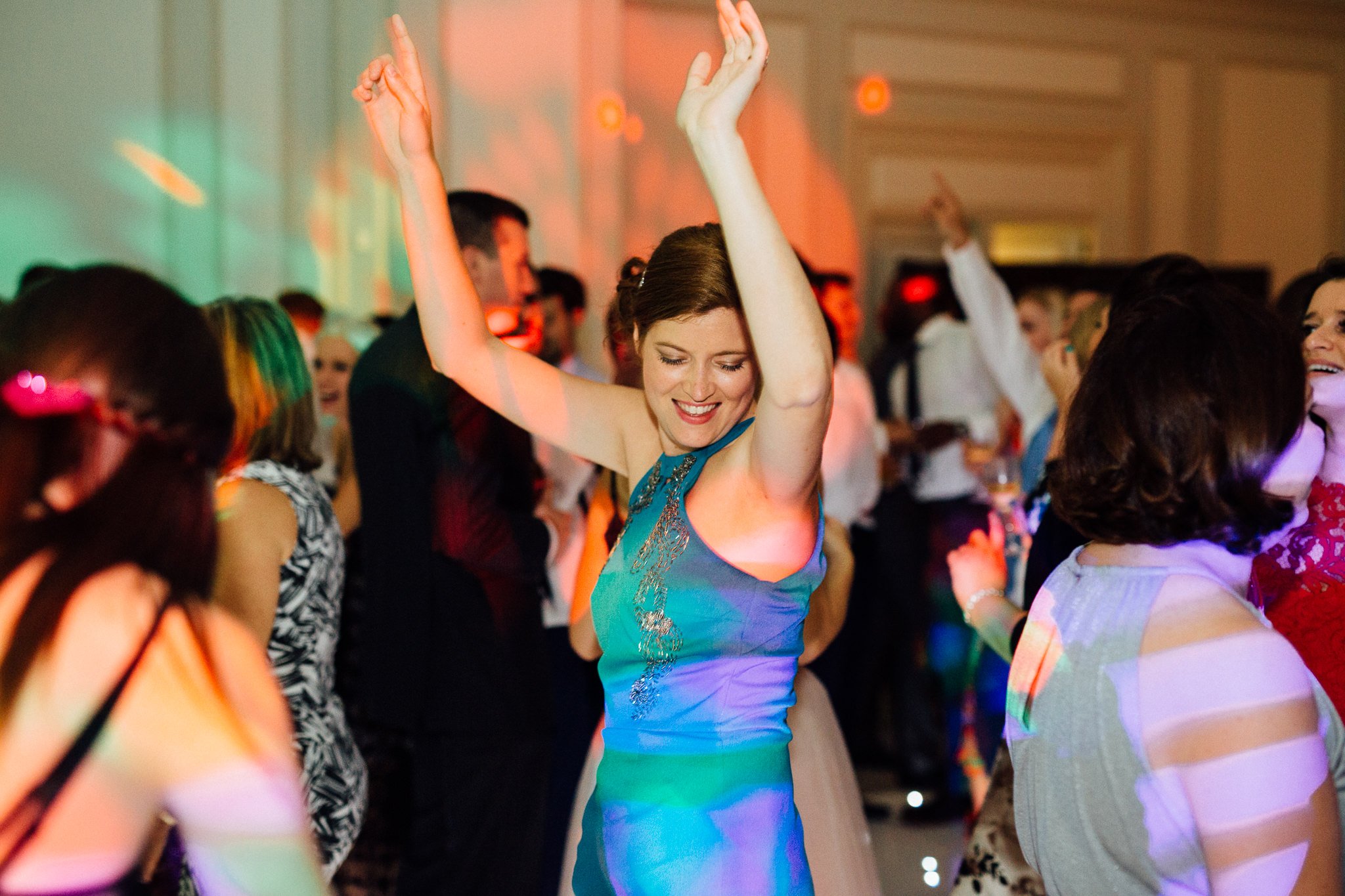  Female guest dancing with her hands in the air. 