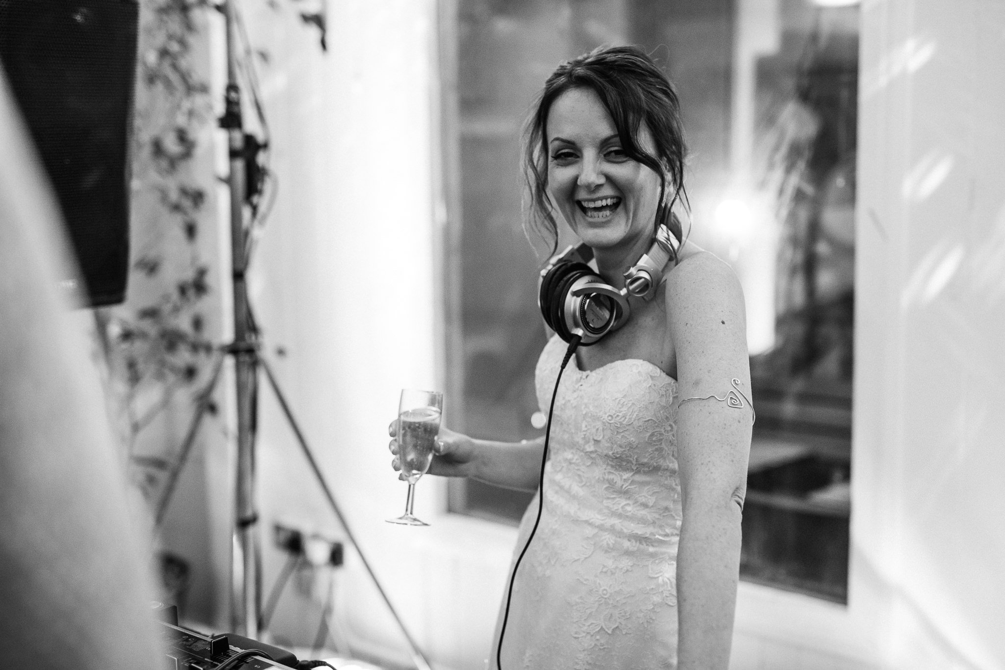  Bride holding champagne with headphone around her neck 