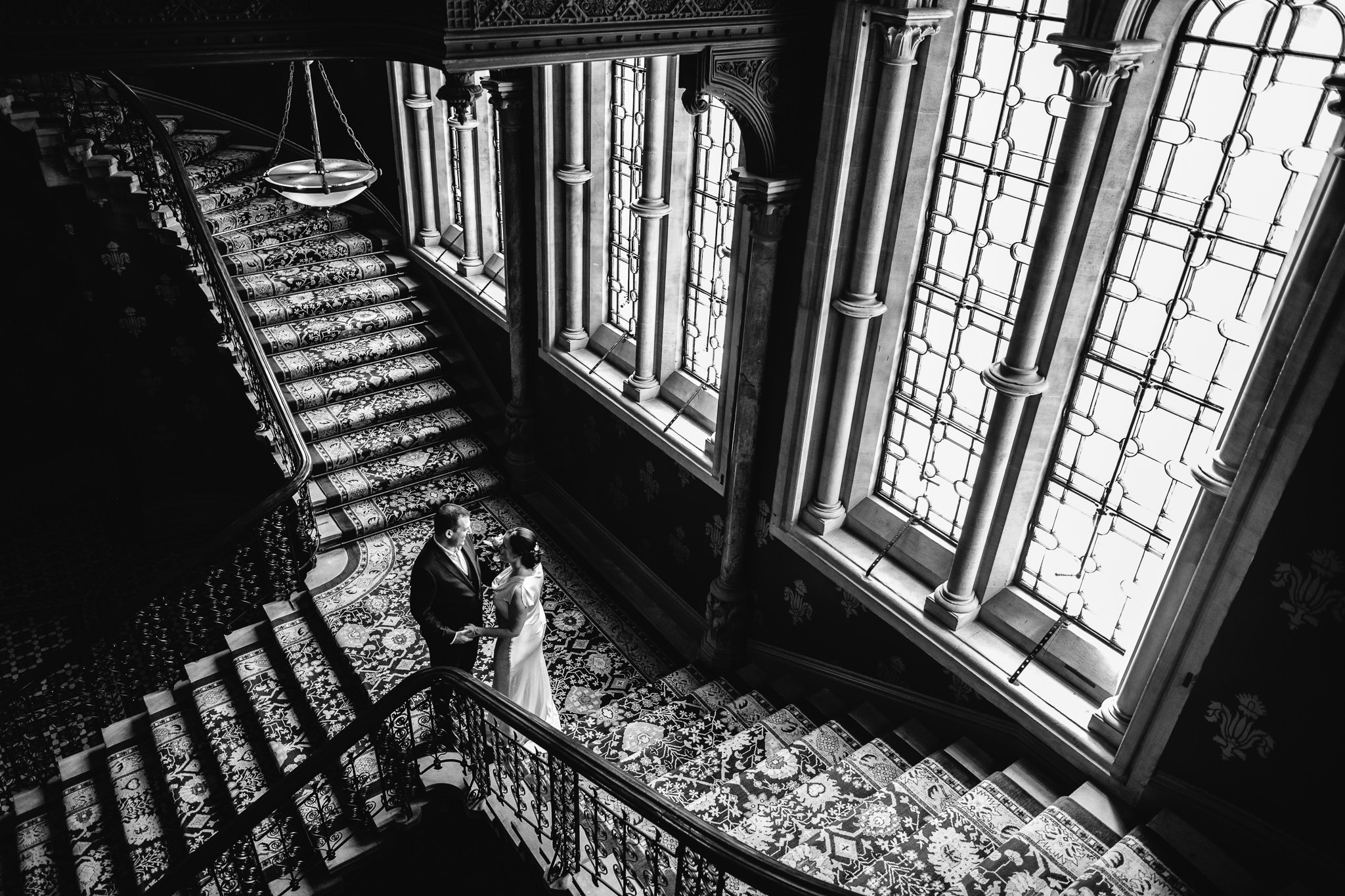  Bride and Groom stand in front of a large window at St. Pancras Renaissance Hotel London 
