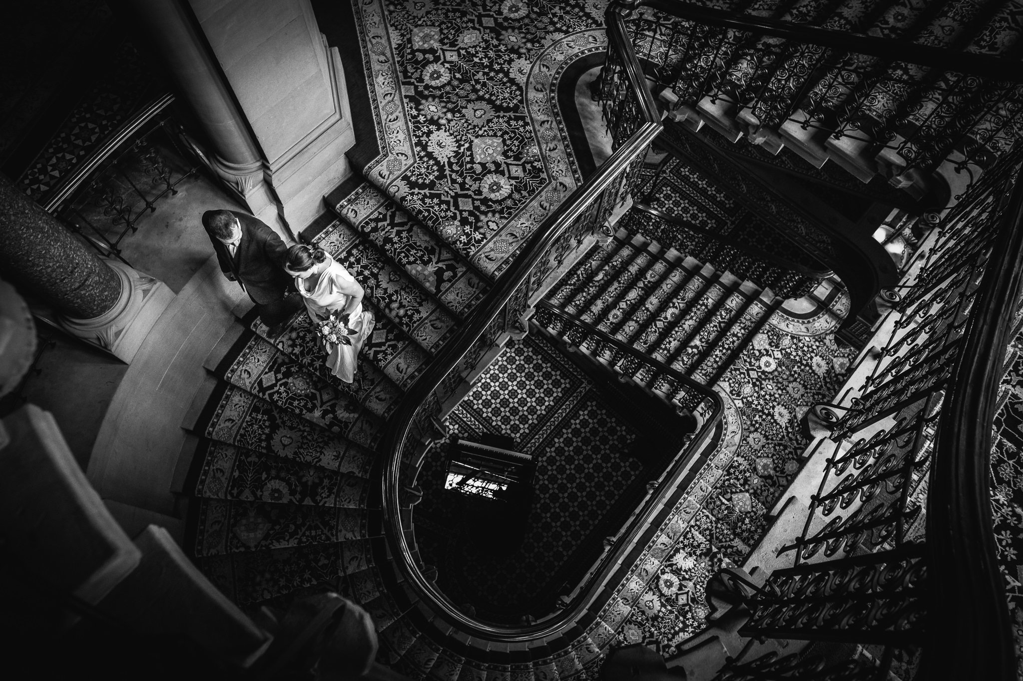  Bride and Groom as seen from above descending a beautiful staircase at St. Pancras Renaissance Hotel London 