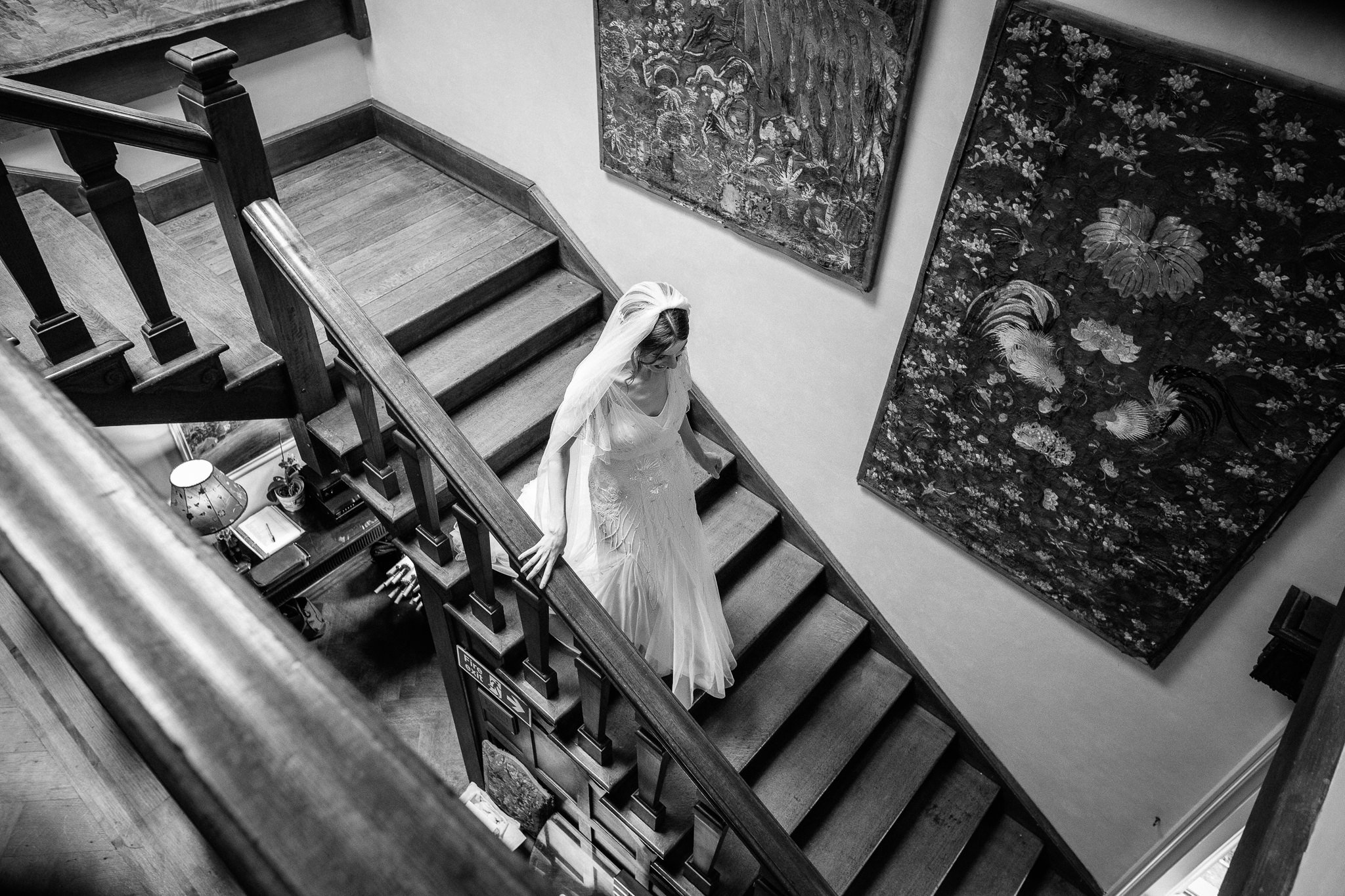  Bride descends the stairs in her wedding dress at  Wadhurst castle wedding venue 