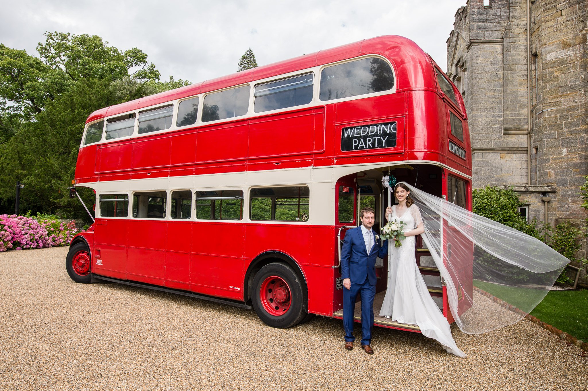  Bride and Groom standing next to a London red bus 