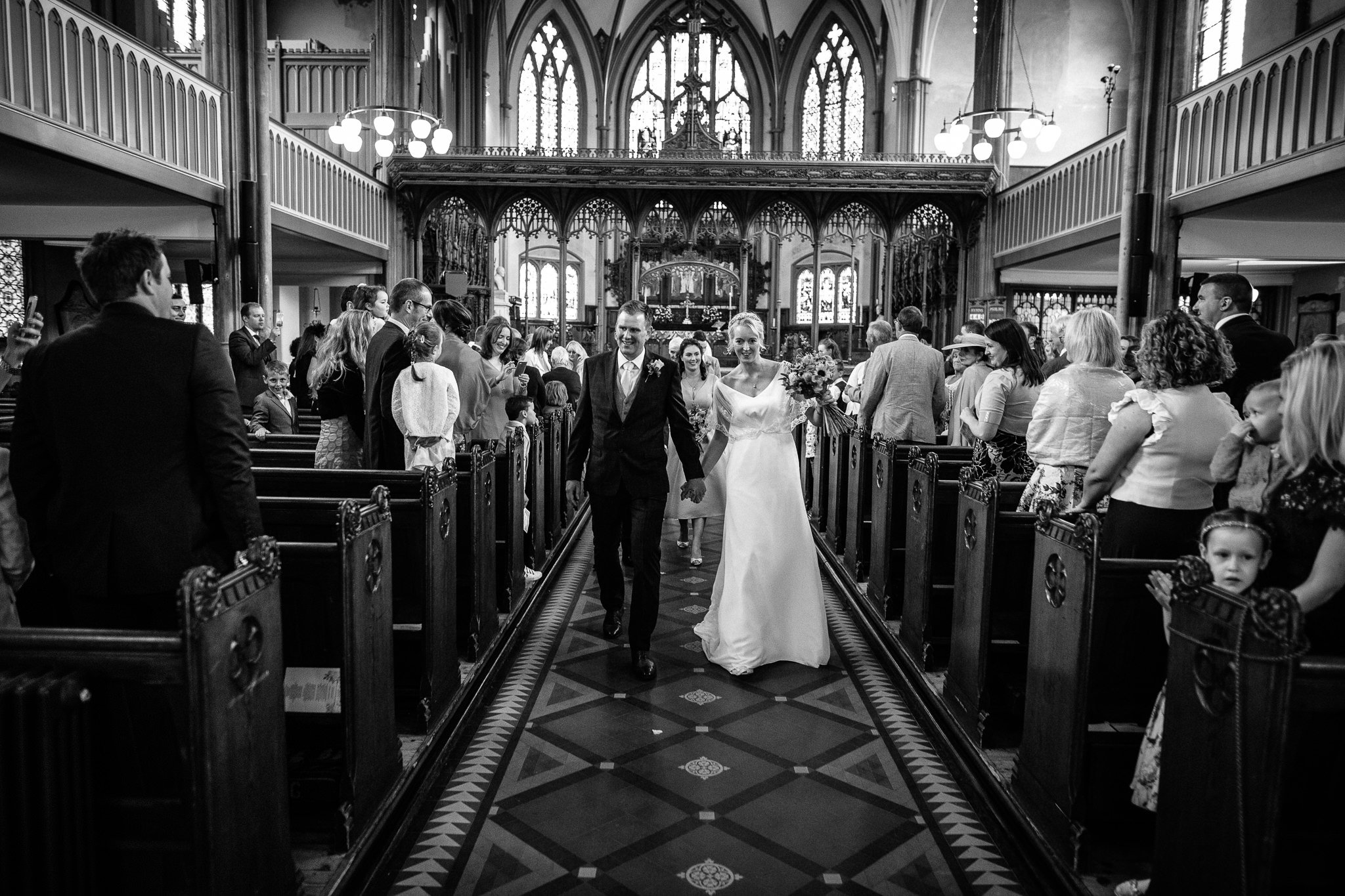  Bride and Groom walk down the aisle as a married couple at All Saints Stand Church Whitefield 