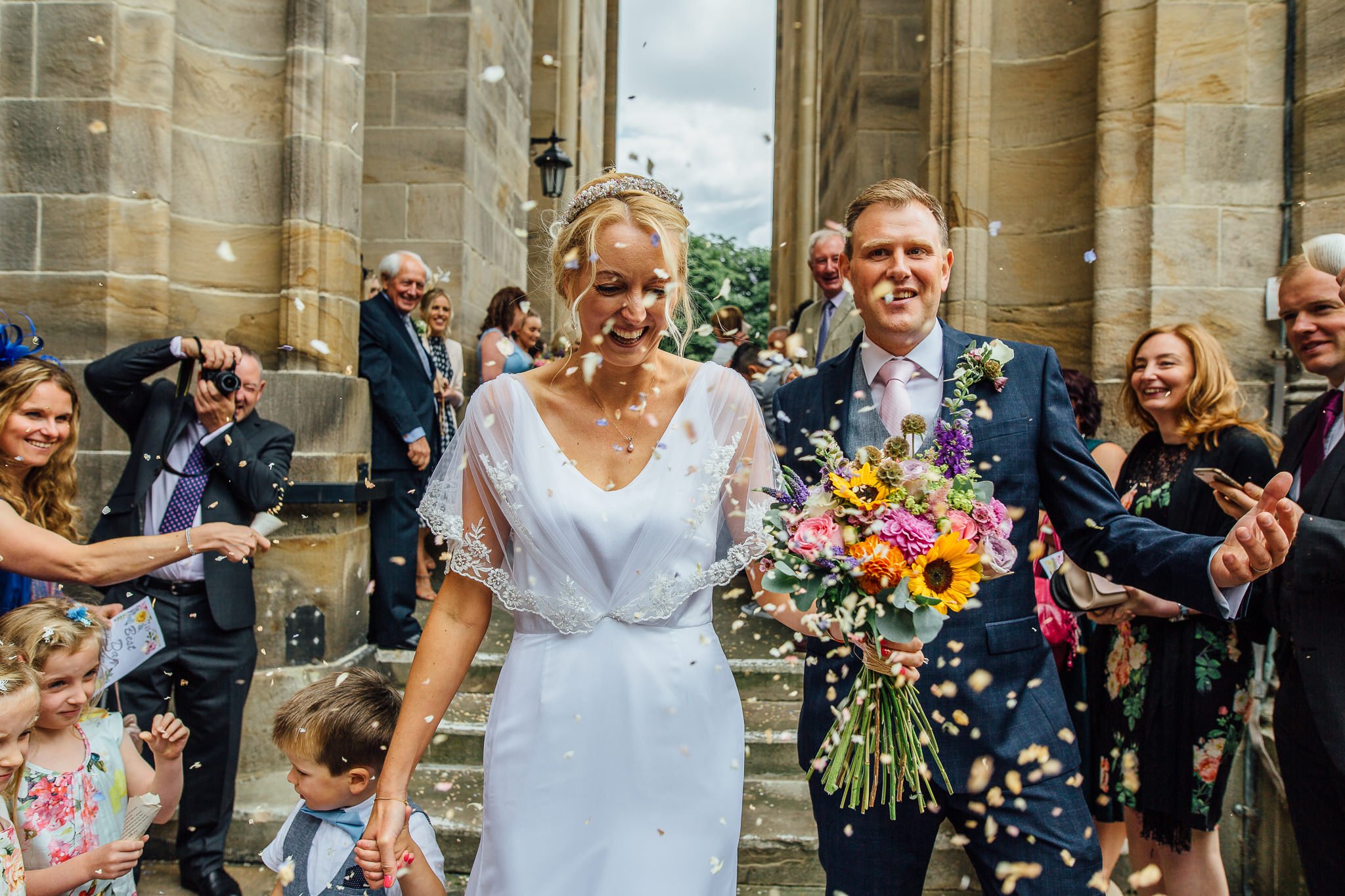  Bride and Groom have confetti thrown at them outside All Saints Stand Church Whitefield 
