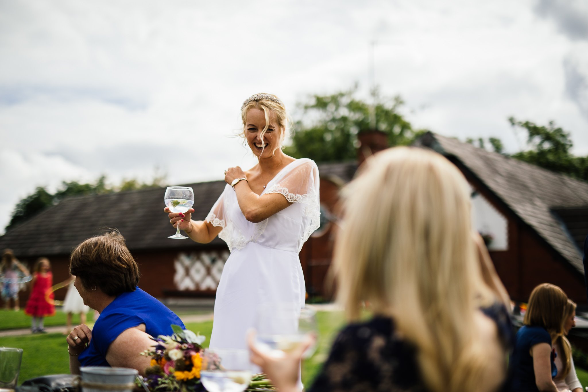  Bride smiling with a drink in hand at The Stables in Bury 