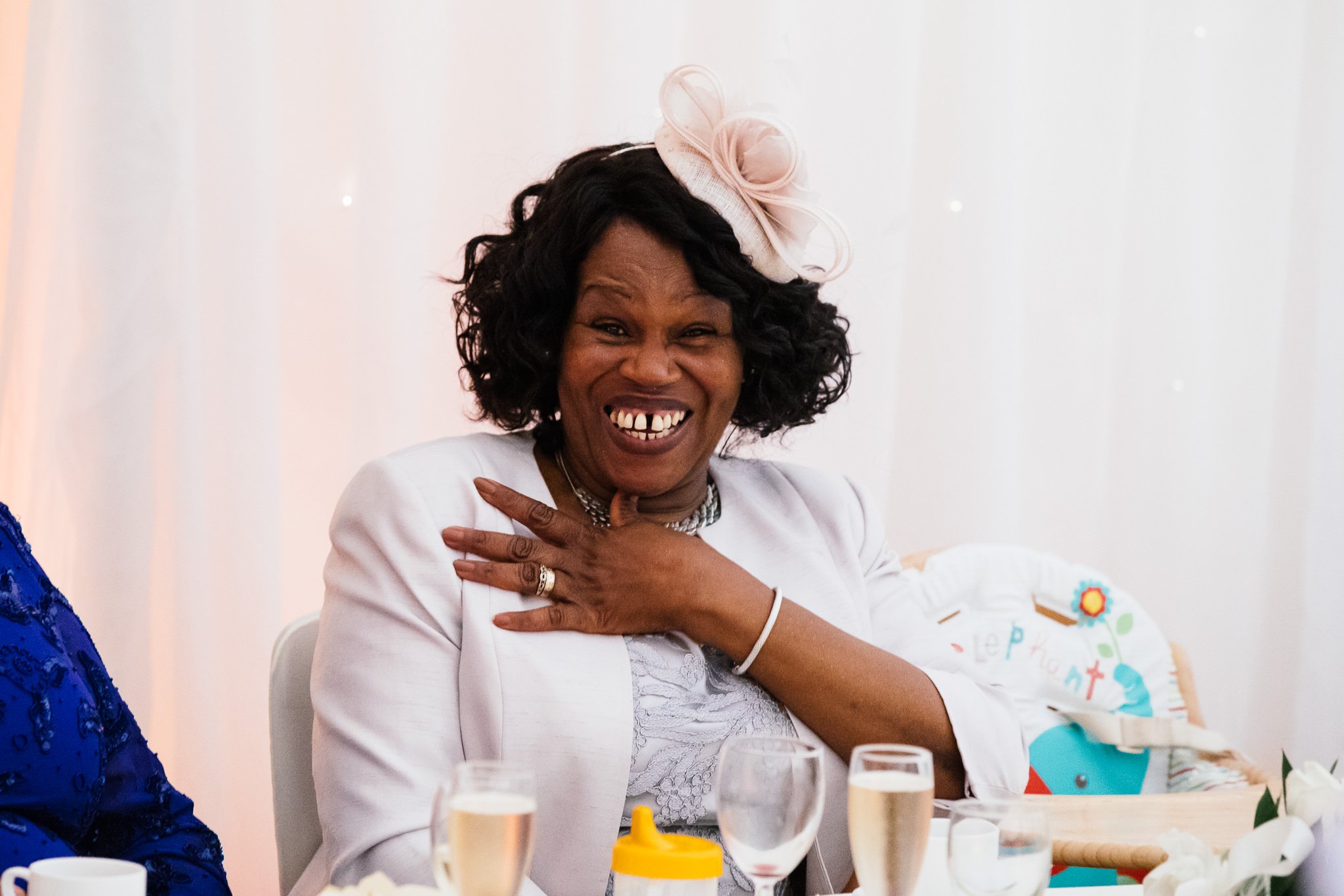  Mother of the bride laughing during the speeches at Newland Hall Essex 