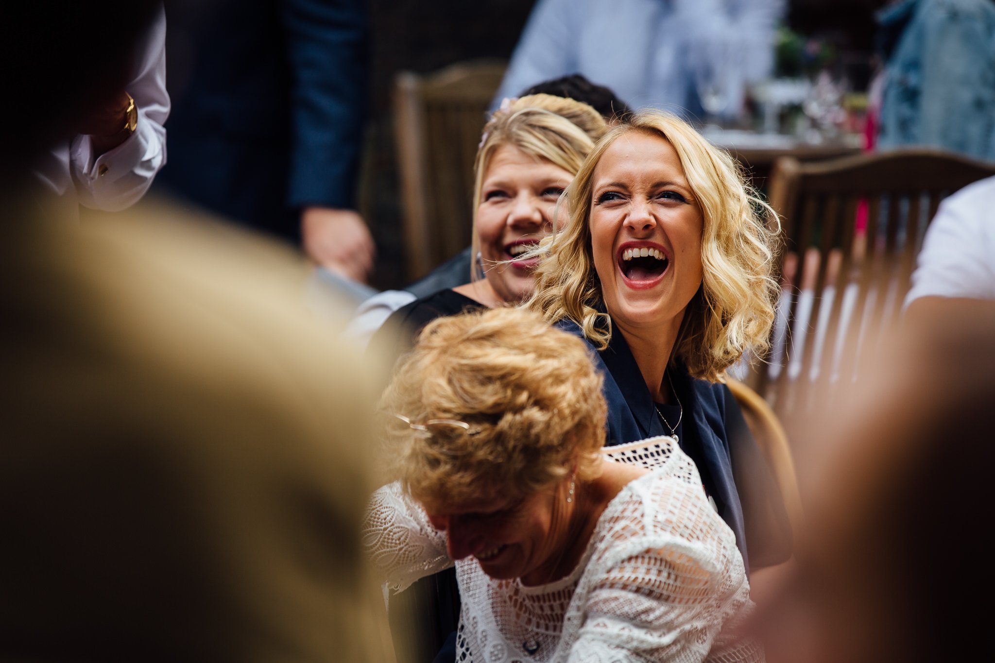  Female guest laughs during the wedding speeches 
