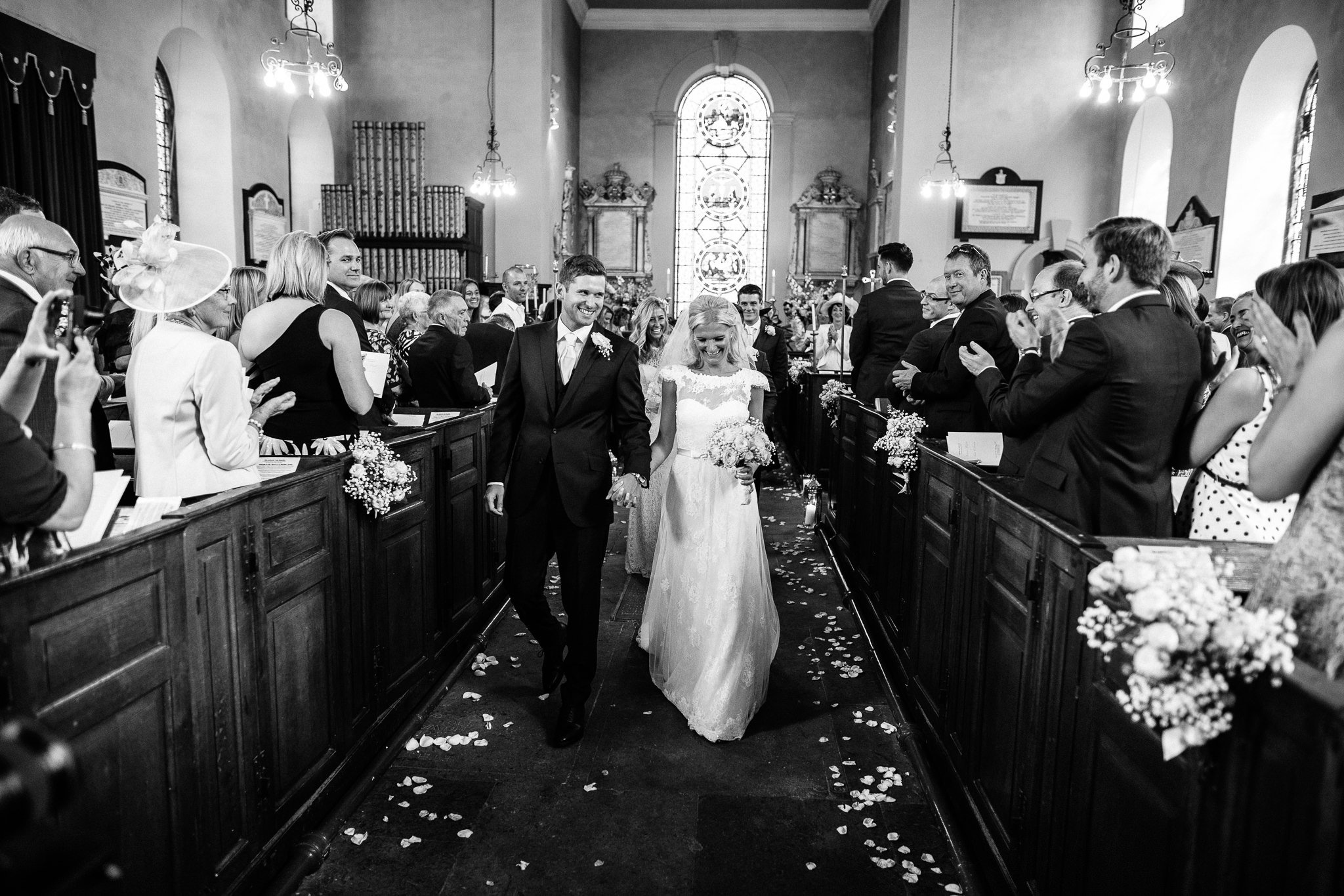  Bride and Groom walk down the aisle after being married at at St Michael's Church Aynho, Banbury OX17 3BQ 