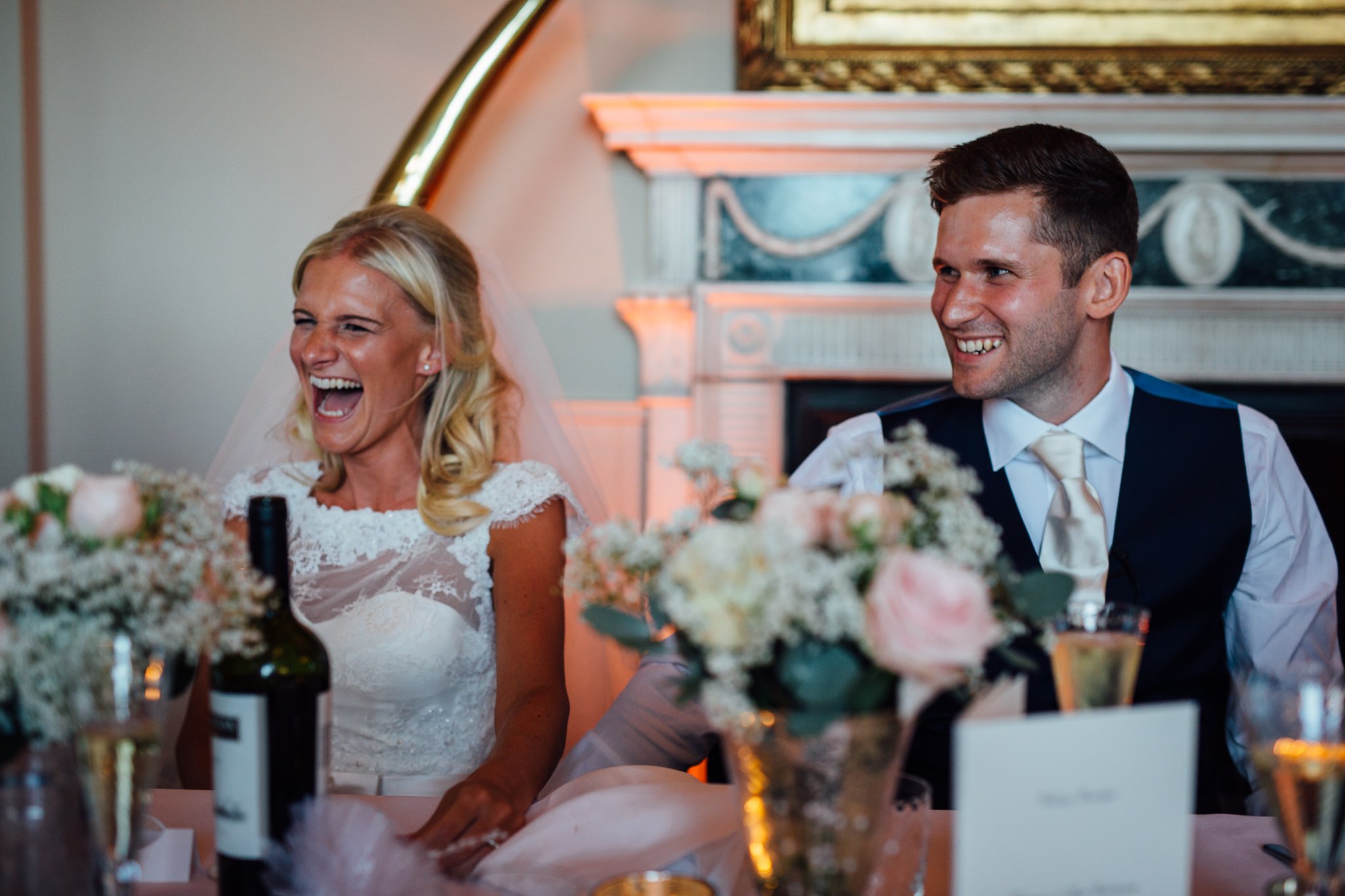  Bride and Groom laugh during the speeches at Aynhoe Park 