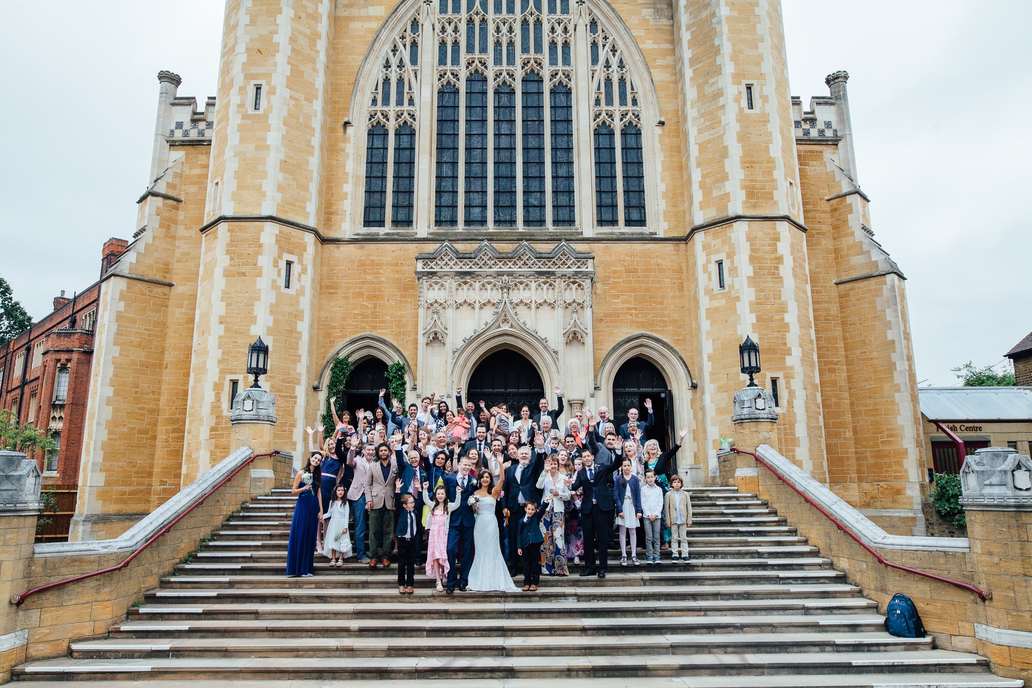  All wedding guests standing on the steps outside Ealing Abbey 