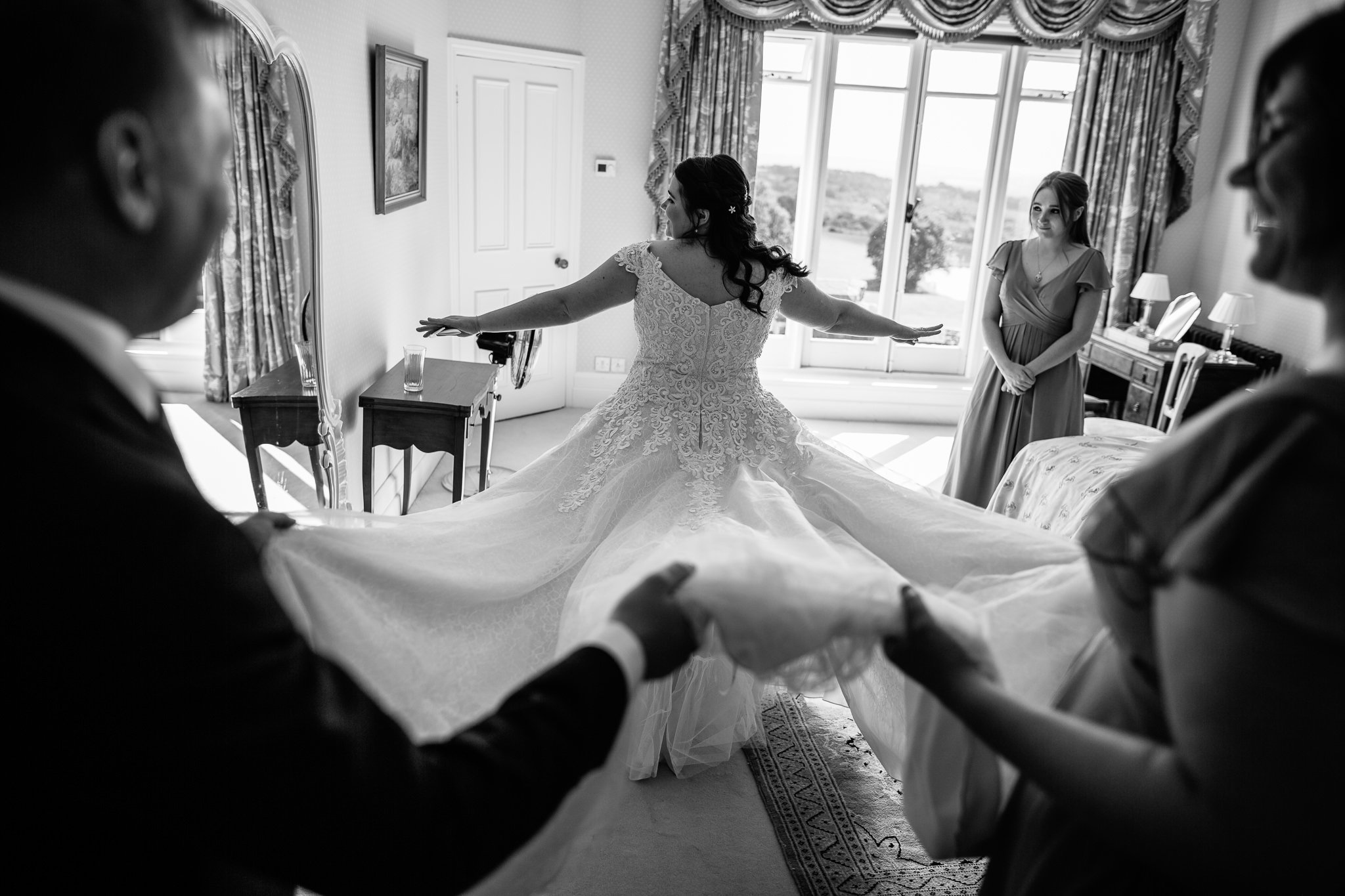  Bride’s wedding dress being held up at Wadhurst Castle 