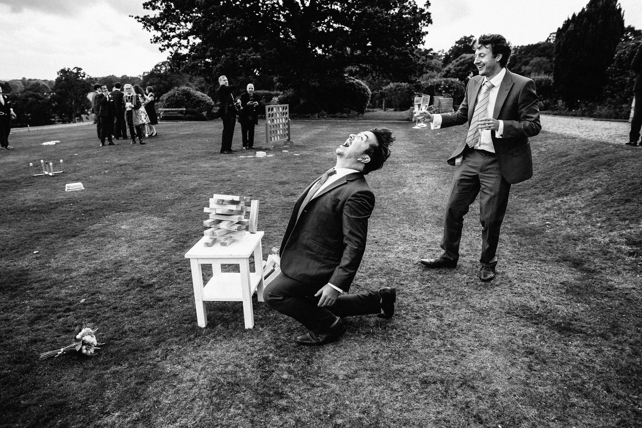  Wedding guest looking angry after failing at Jenga in the gardens of Wadhurst Castle 