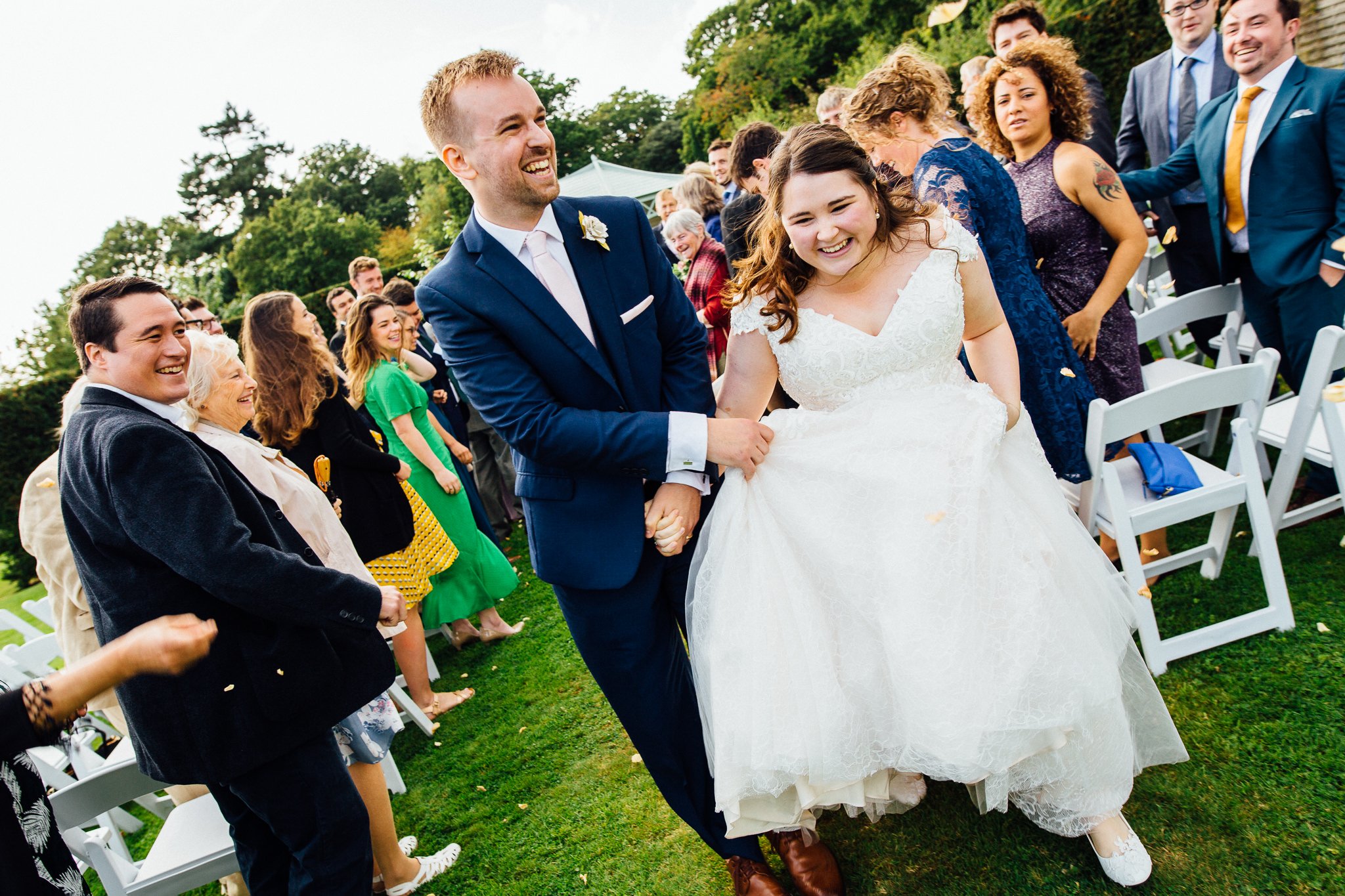  Bride and Groom walk up the aisle as married couple in the walled garden at Wadhurst Castle 
