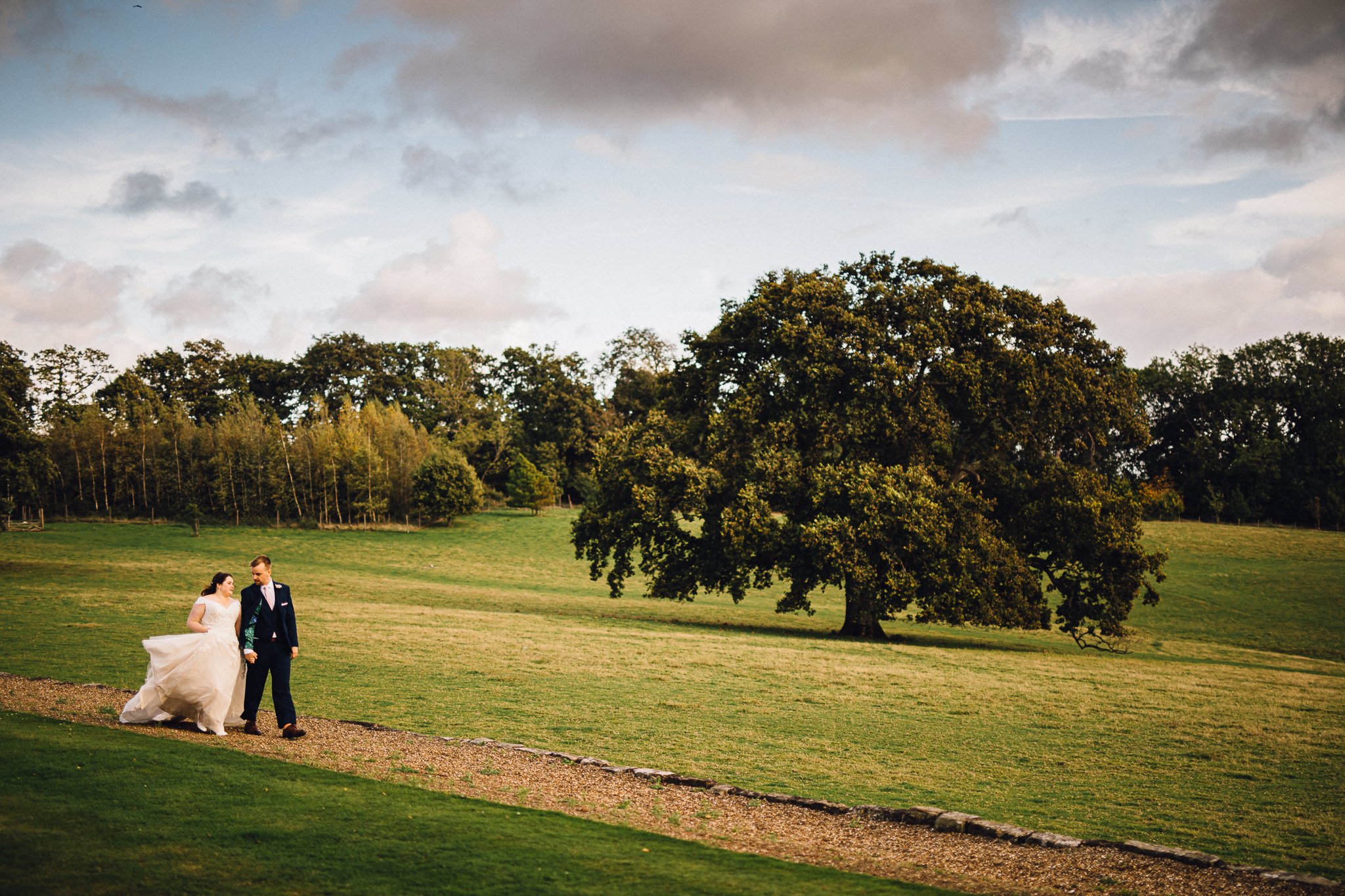  Bride and Groom walking in the grounds of Wadhurst Castle on their wedding day 