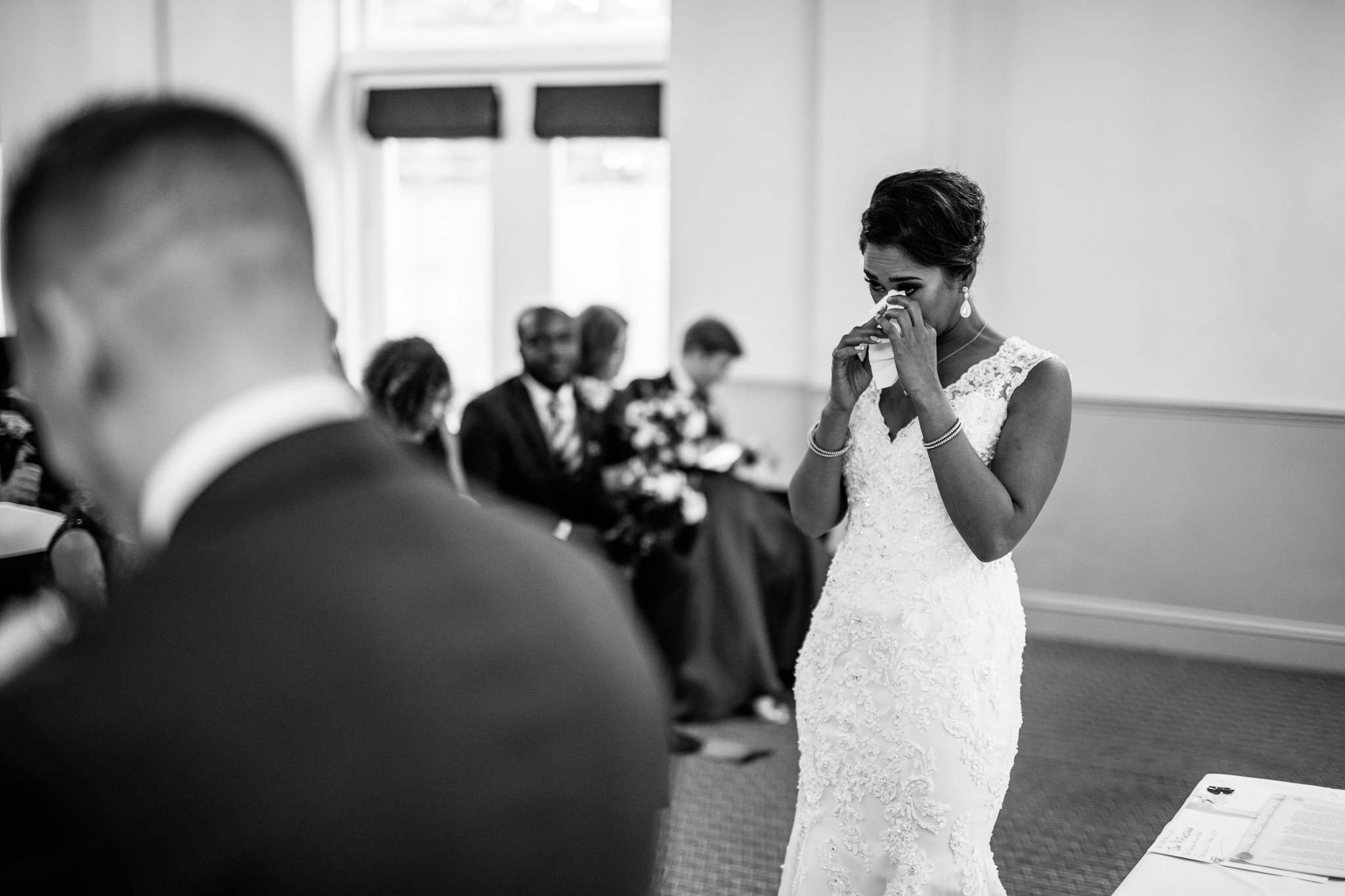  Bride wiping away a tear during the wedding ceremony at Coulsdon Manor Hotel 