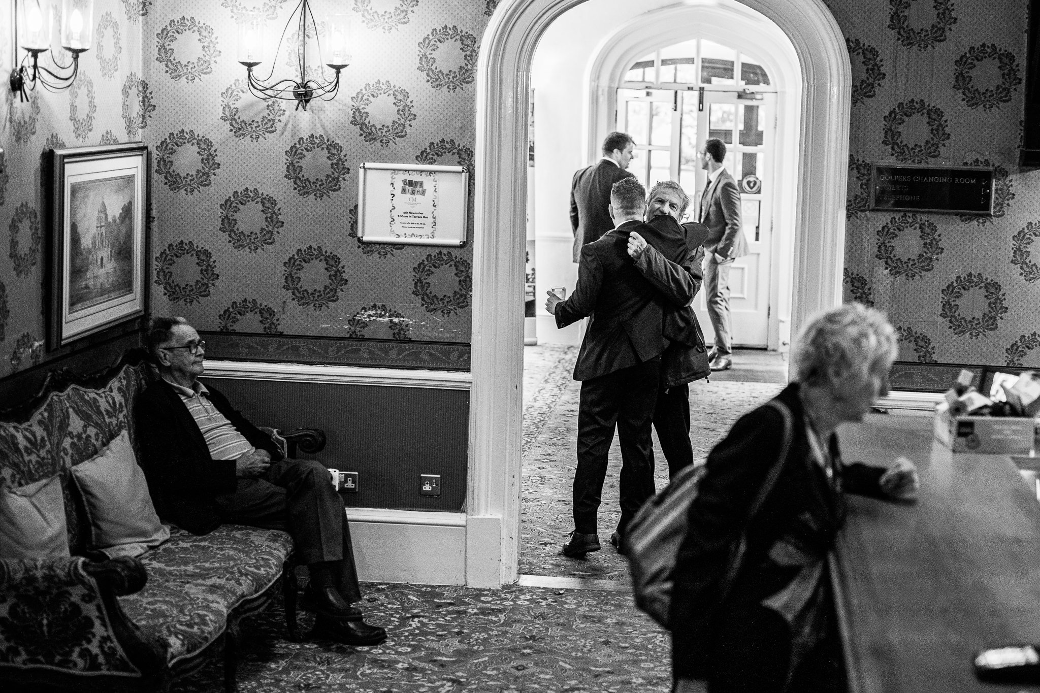  Groom hugging his rather in the reception area of Coulsdon Manor Hotel 