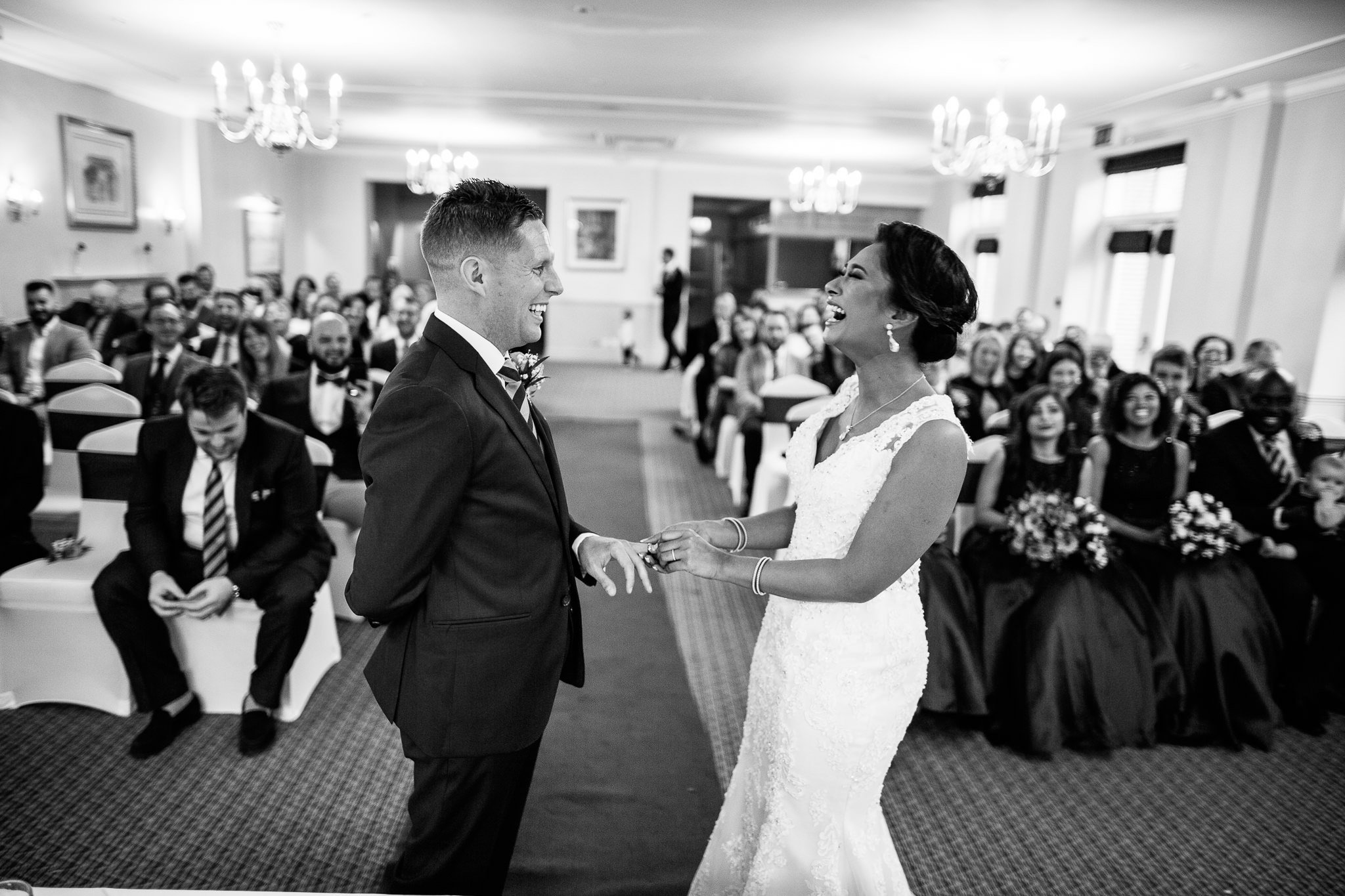  Bride and Groom laughing during the wedding ceremony at Coulsdon Manor Hotel 