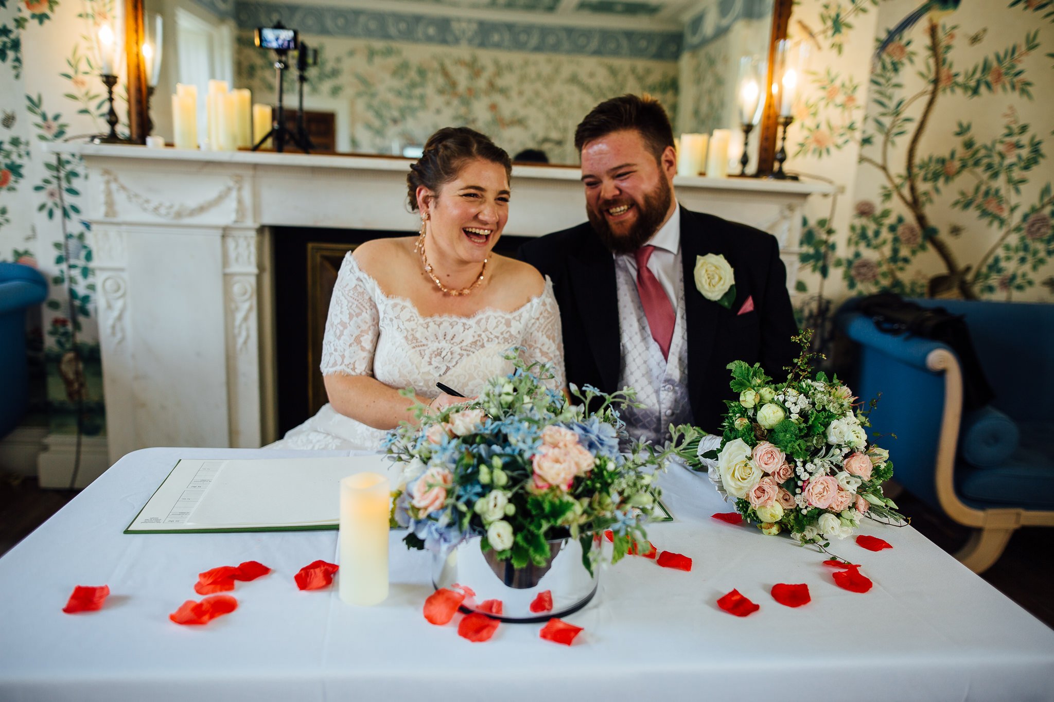  Bride and GRoom laughing whilst signing the wedding documents at  Pitzhanger Manor 