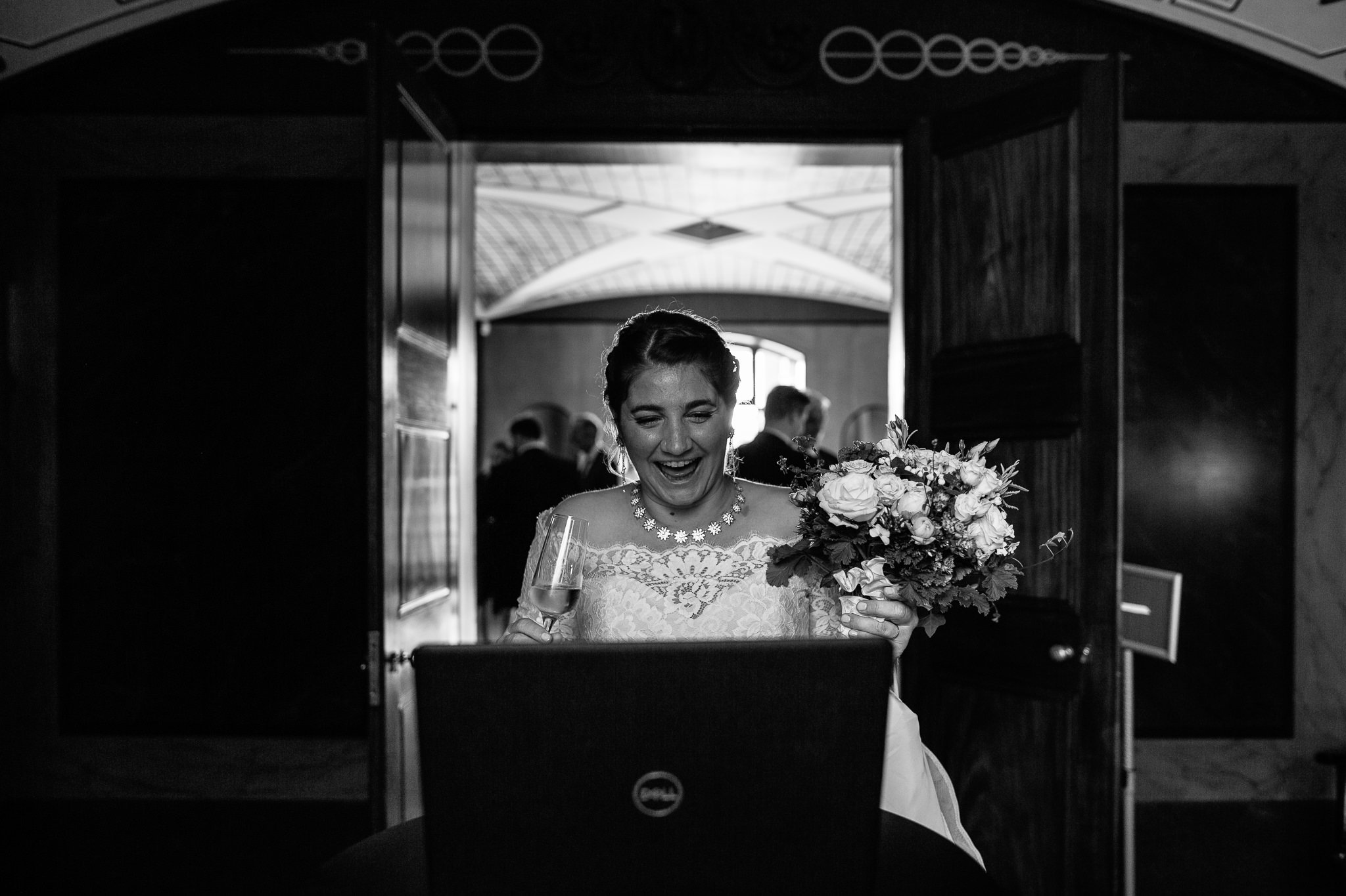  Bride laughing whilst talking to a family member via Zoom at  Pitzhanger Manor 