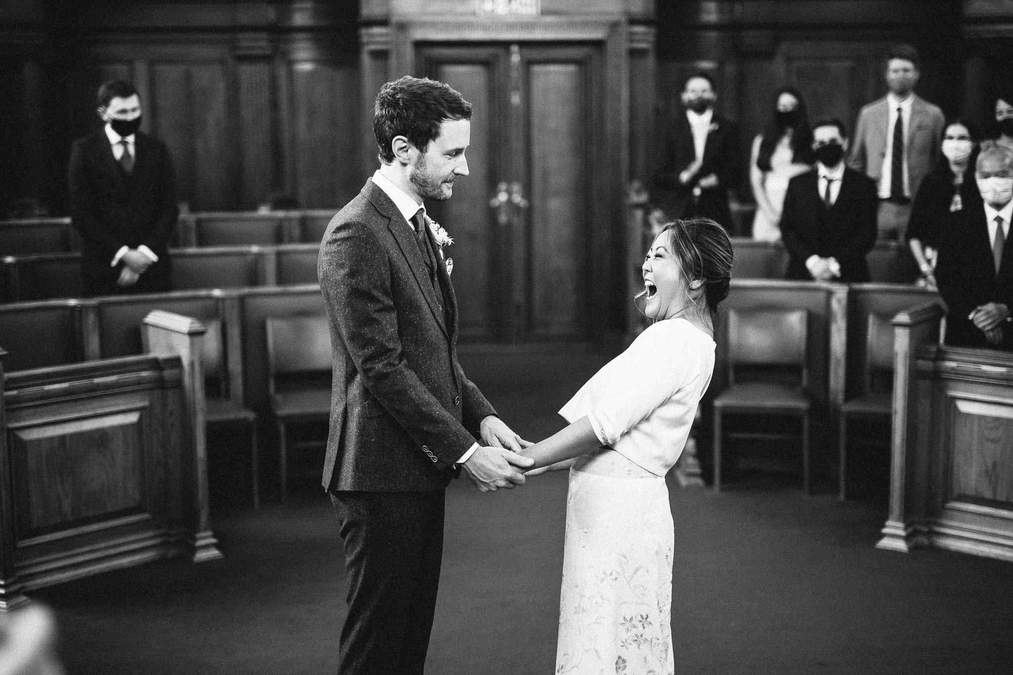  Bride and Groom holding hands during the wedding ceremony at  Islington Town Hall 