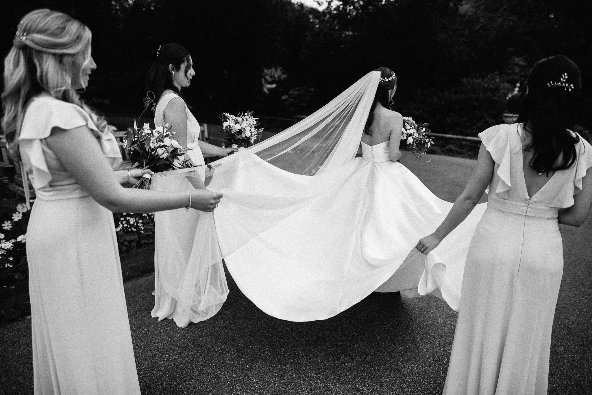  Bridesmaids carry the wedding dress train of the Bride at The Hurlingham Club  