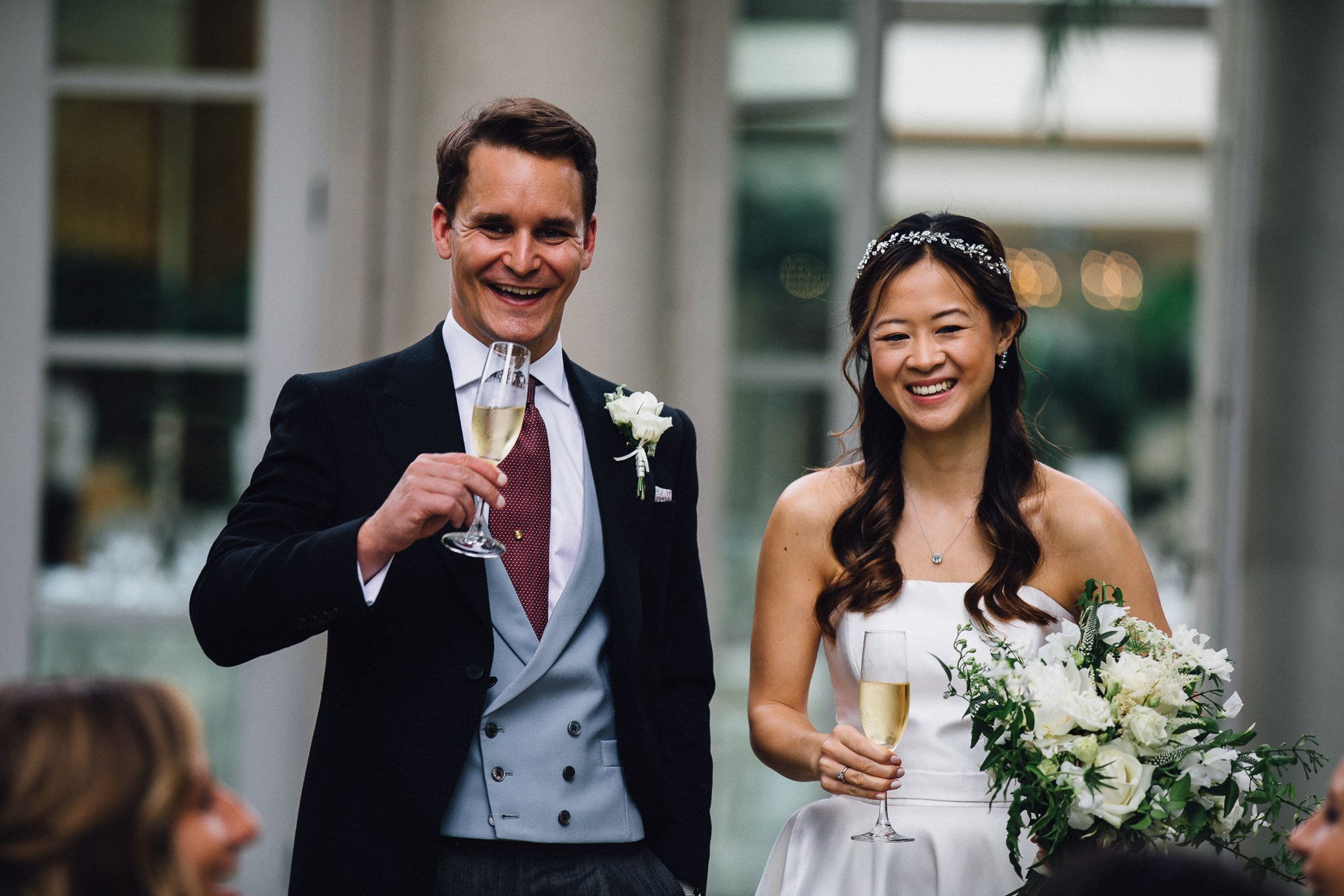  Bride and Groom smiling whilst drinking champagne at Hurlingham Club 