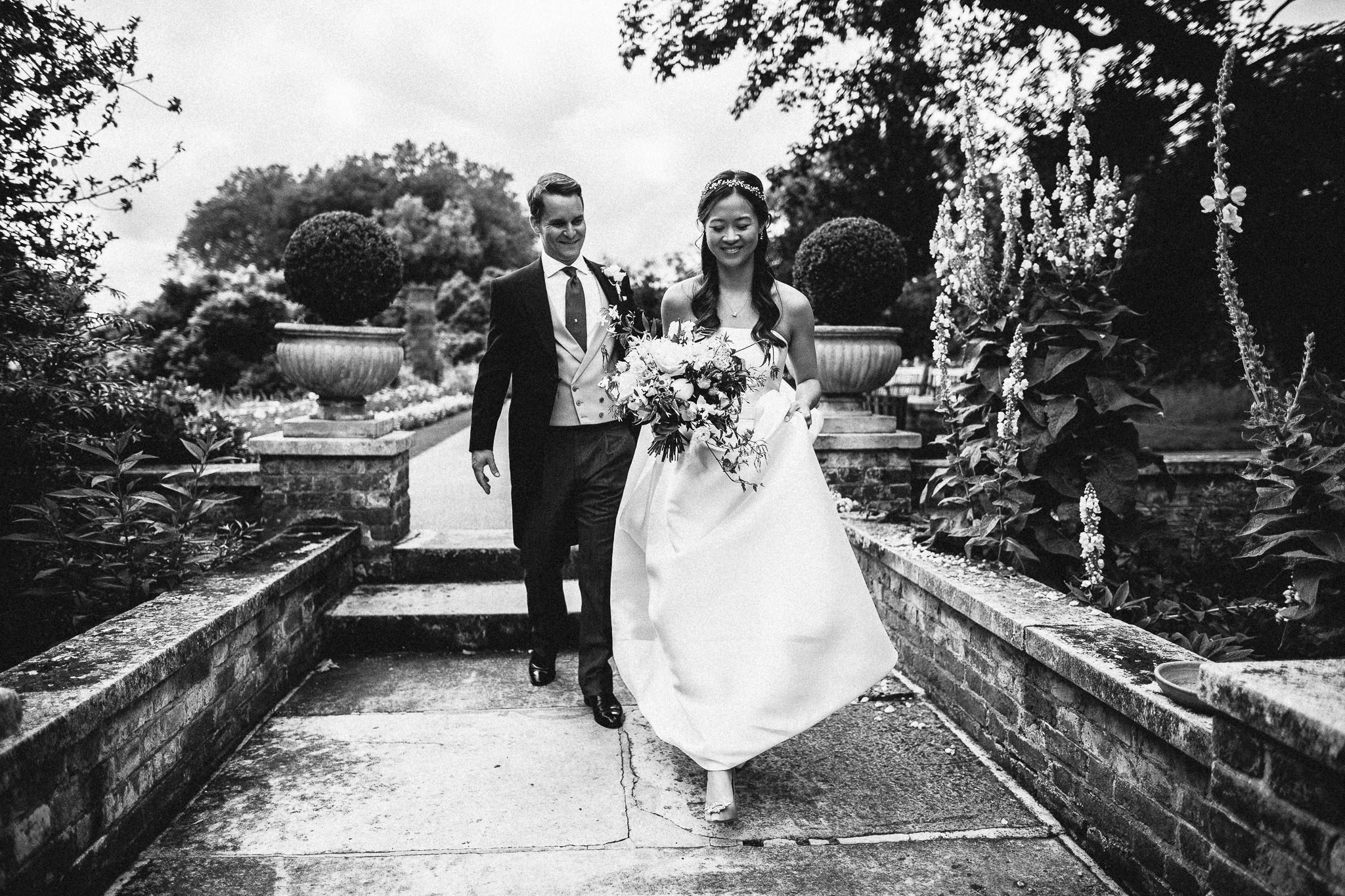  Bride and Groom walking through the gardens of the Hurlingham Club 