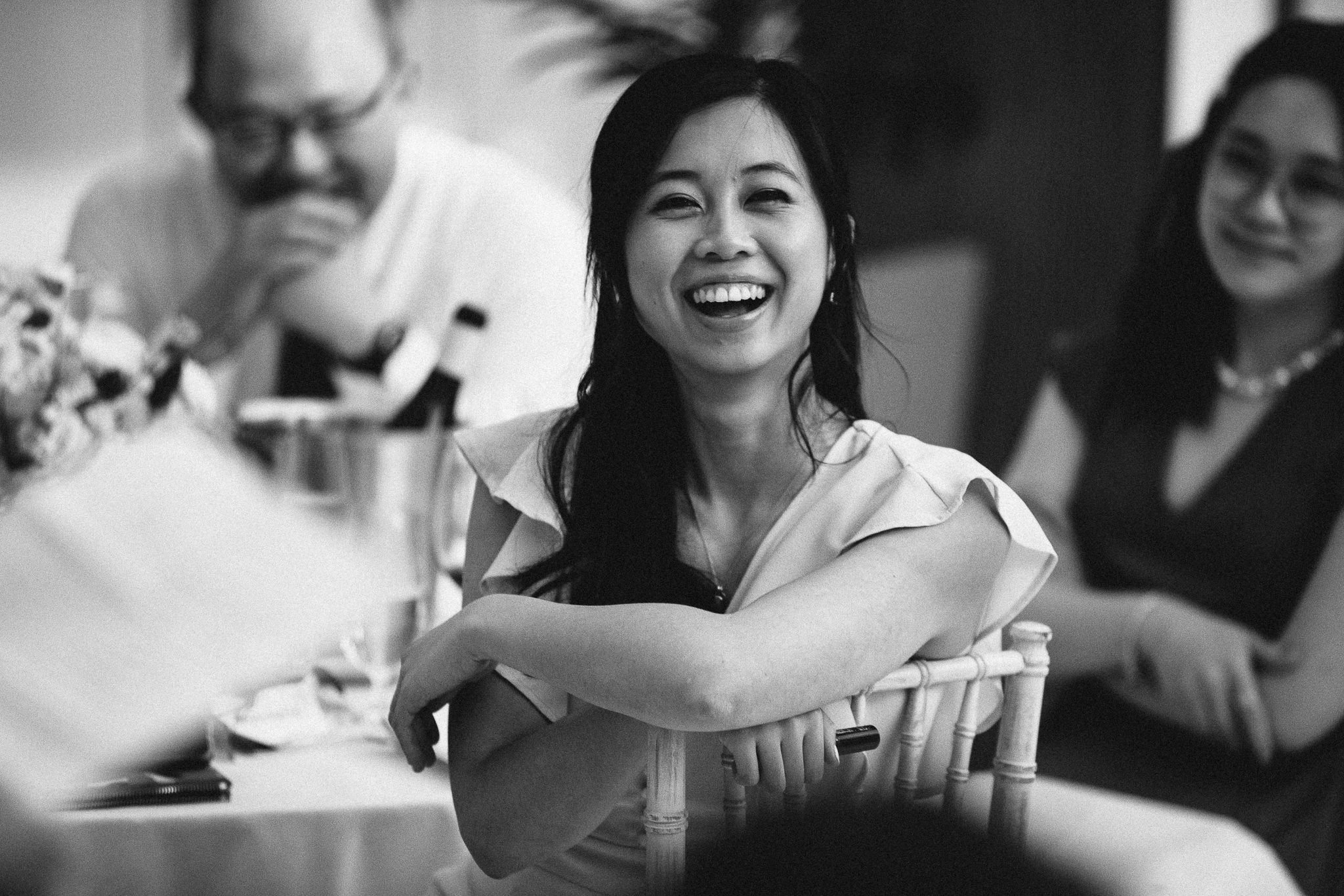  Wedding guest laughing during the speeches at Hurlingham Club 