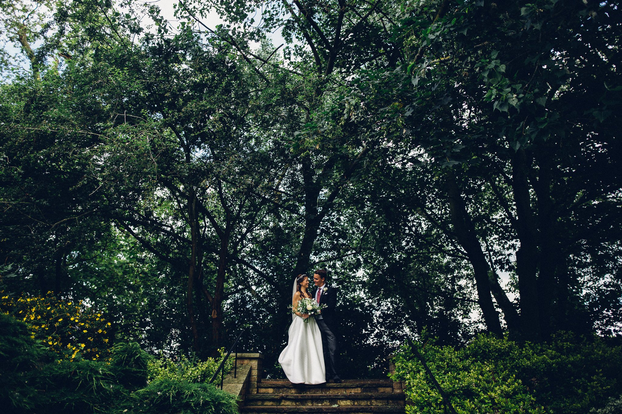  Bride and Groom walking through the wooded area at Hurlingham Club 