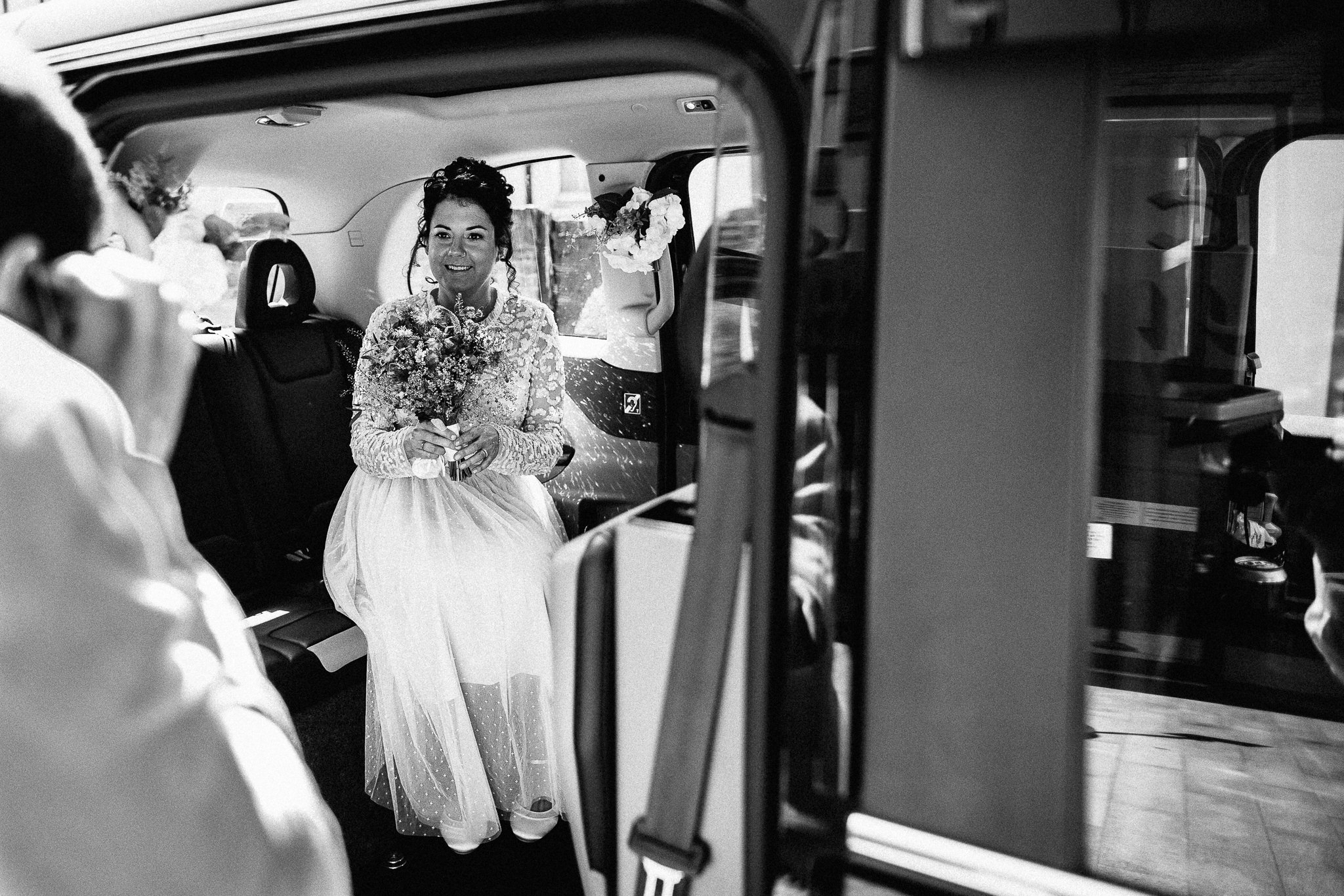  Bride in a black cab after their wedding at Hammersmith Register Office 