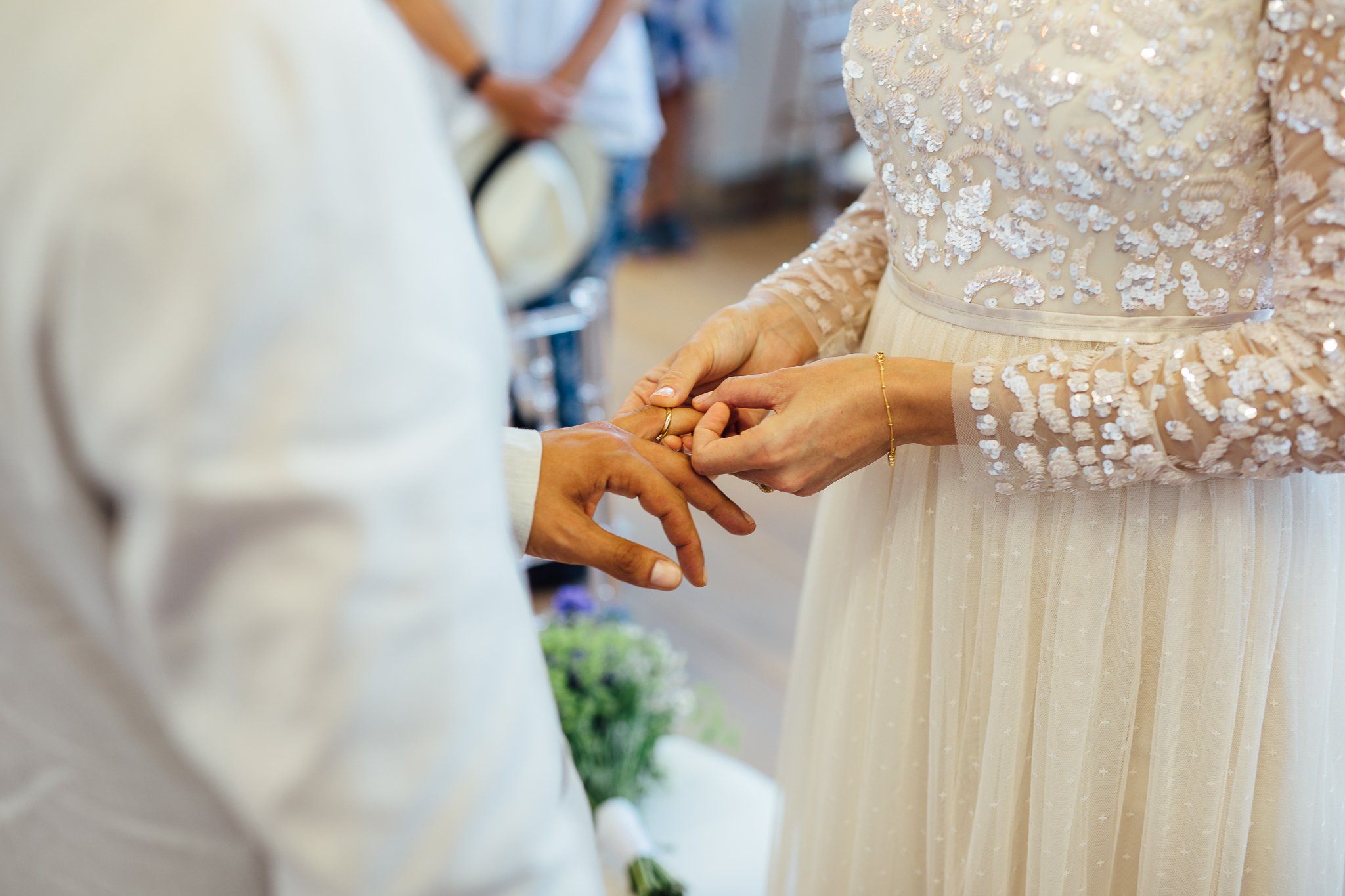  Bride putting a ring on the groom’s finger during the wedding ceremony at Hammersmith Register Office. 