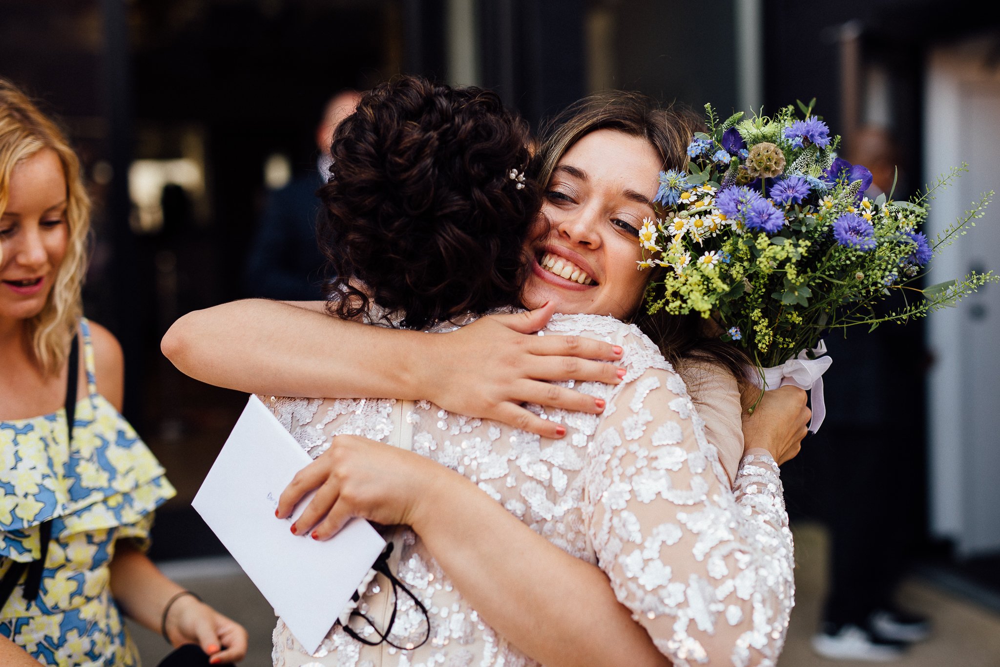  Guest hugging the bride outside of Hammersmith Register Office. 