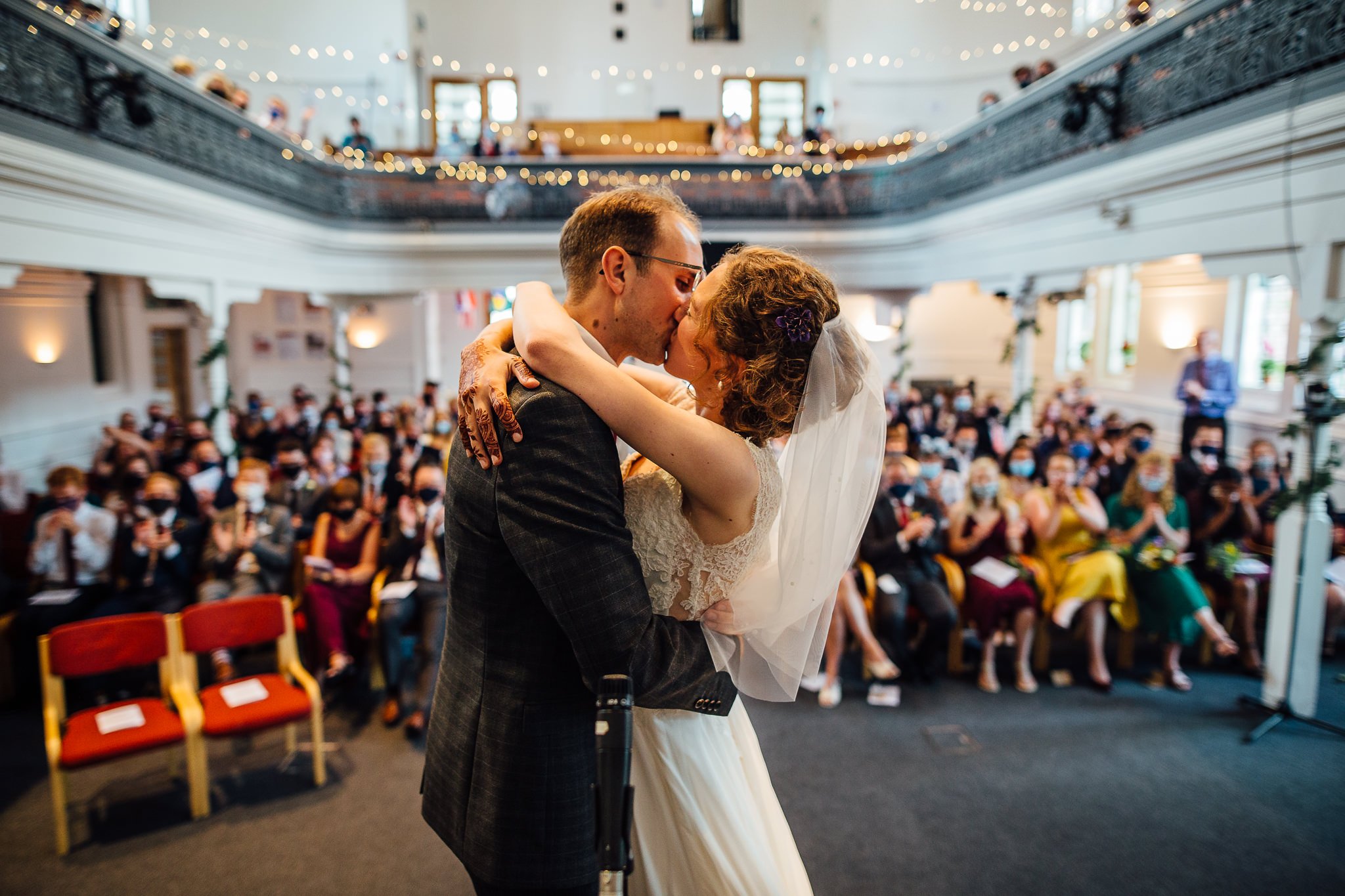  Bride and Groom kissing in front of the wedding guests after being married at Wycliffe Baptist Church in Reading 