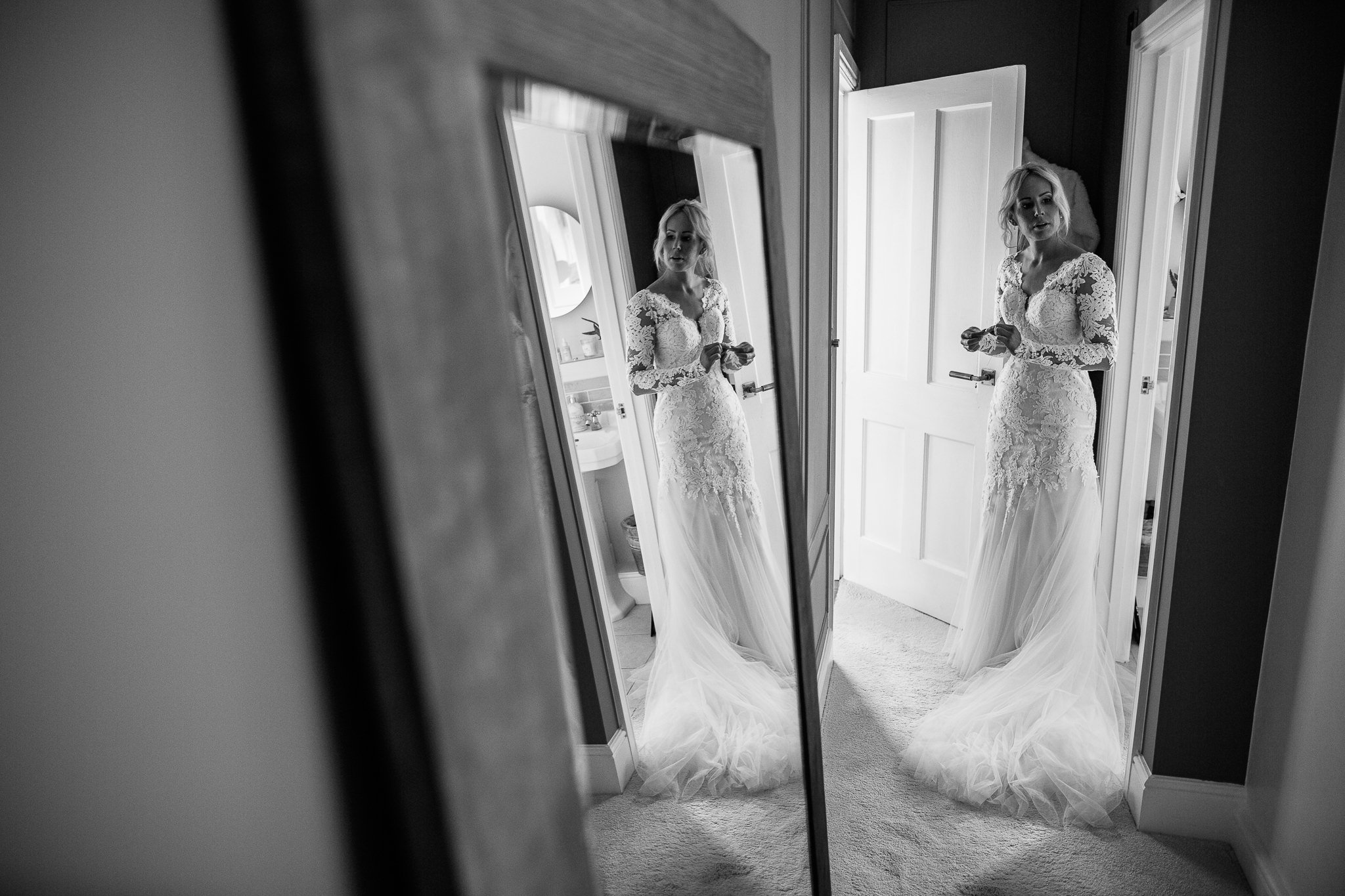  Bride in her wedding dress with a mirror showing her reflection 