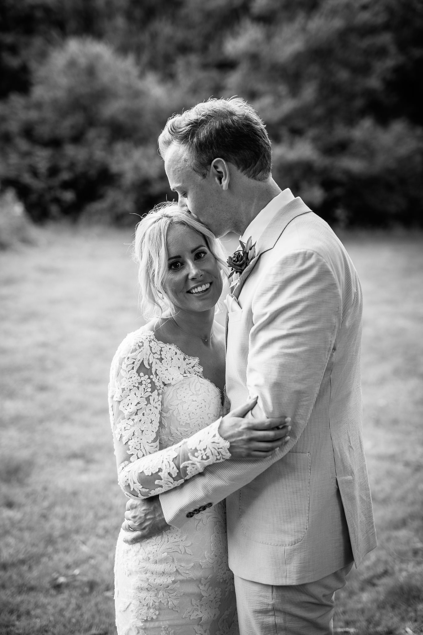  Groom kissing the bride on the head as they hold each other 