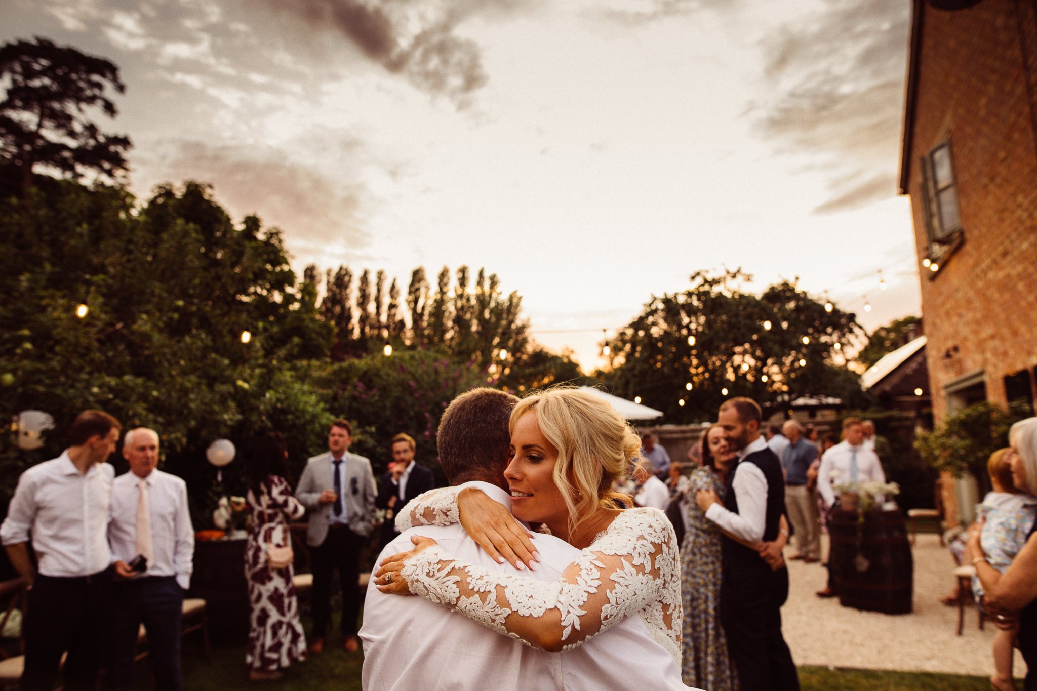  Bride hugs her Dad as the sun sets behind them 