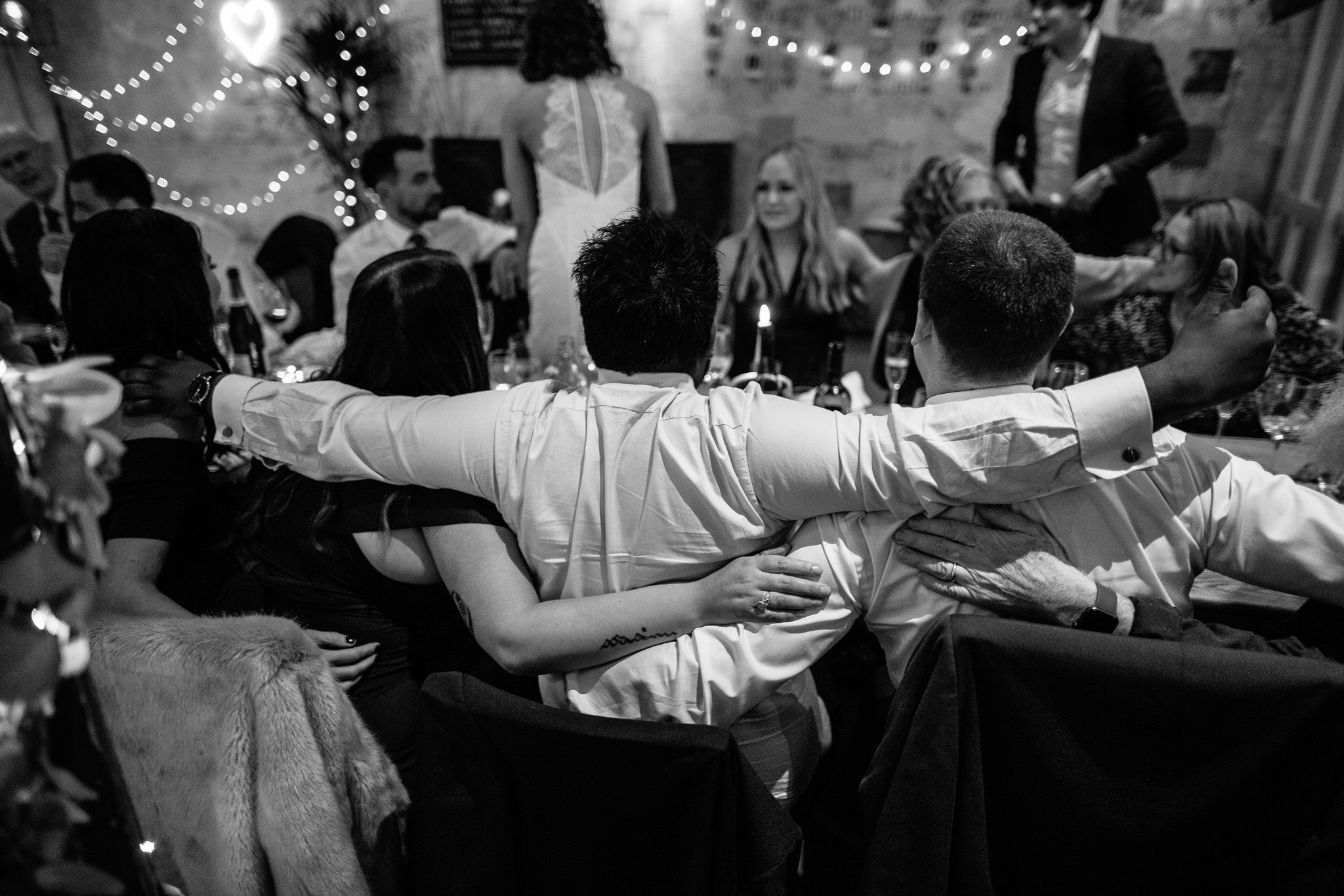  Wedding guests with their arms around each other 