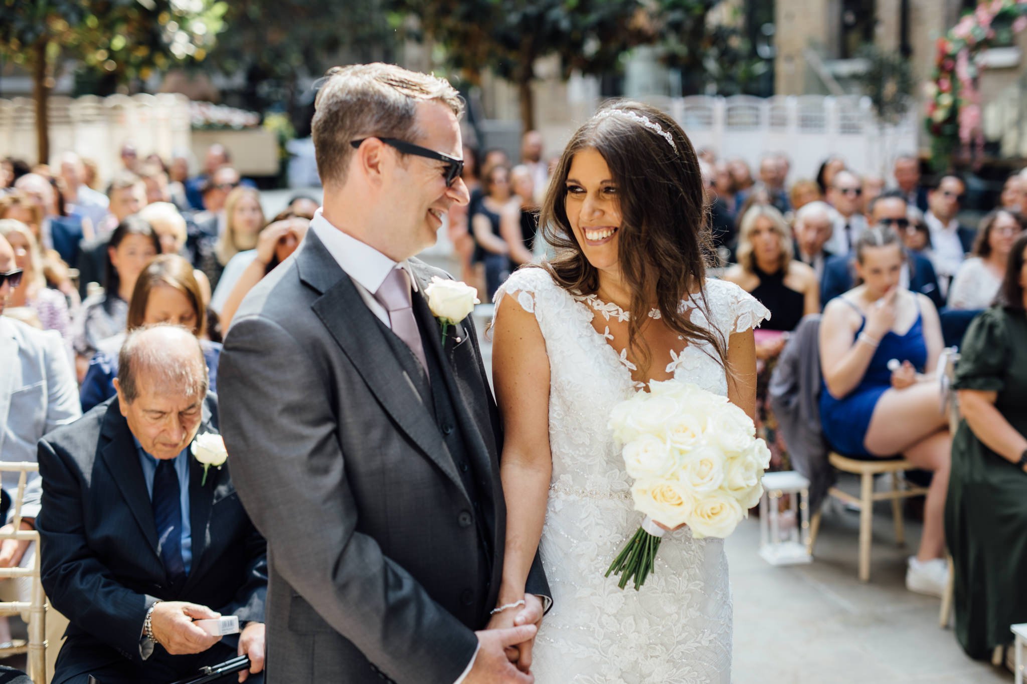  Bride and Groom smiling and holding hands during their ceremony at Devonshire Terrace 